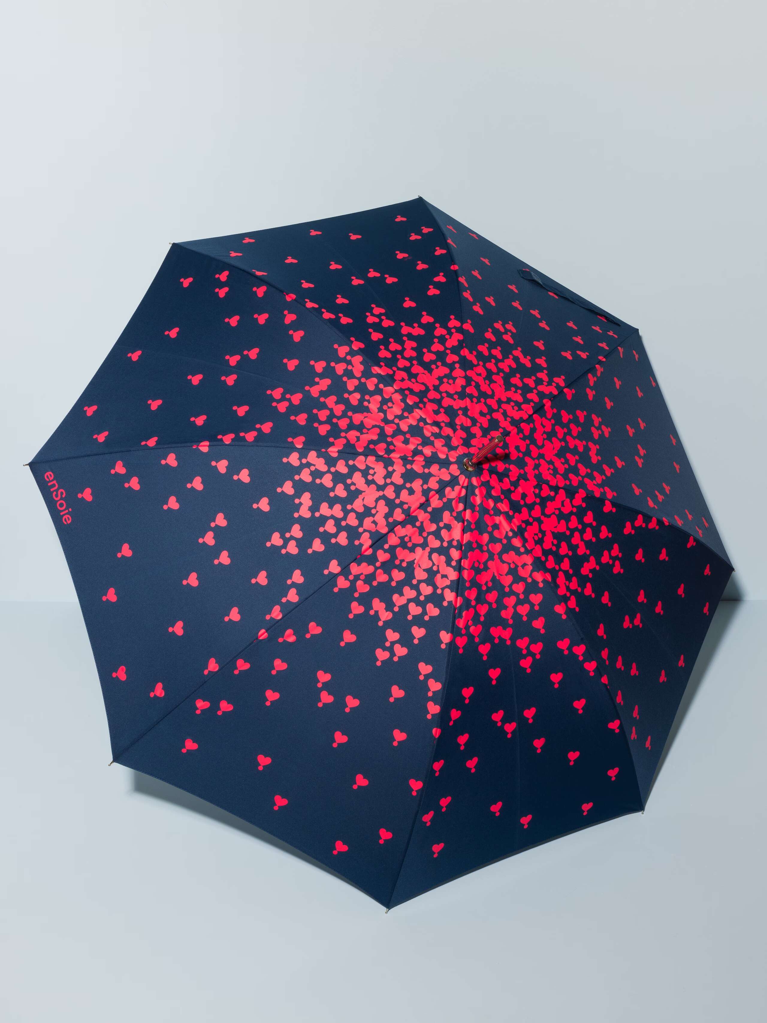 Picture of a navy blue umbrella featuring a beautiful heart print in red