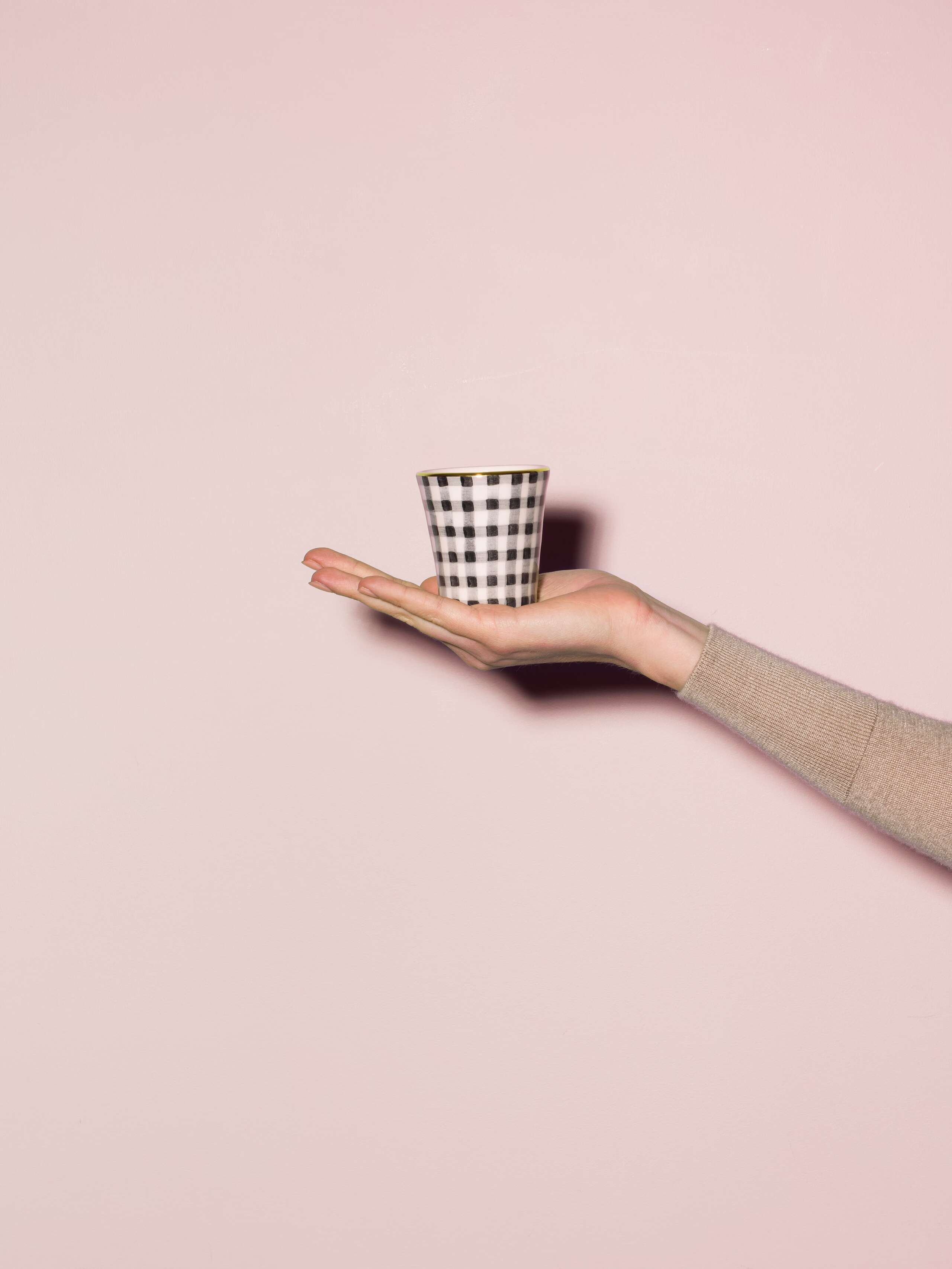 Picture of a hand made and hand printed espresso cup made of ceramic featuring a beige vichy check pattern
