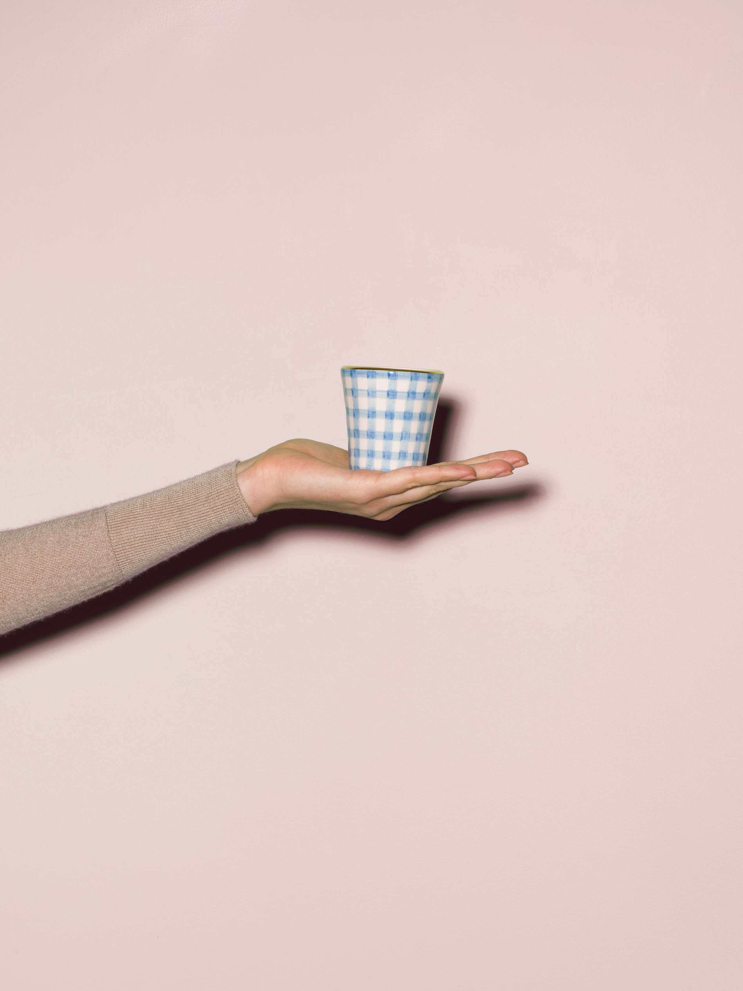 Picture of a hand made and hand printed espresso cup made of ceramic featuring a light blue vichy check pattern