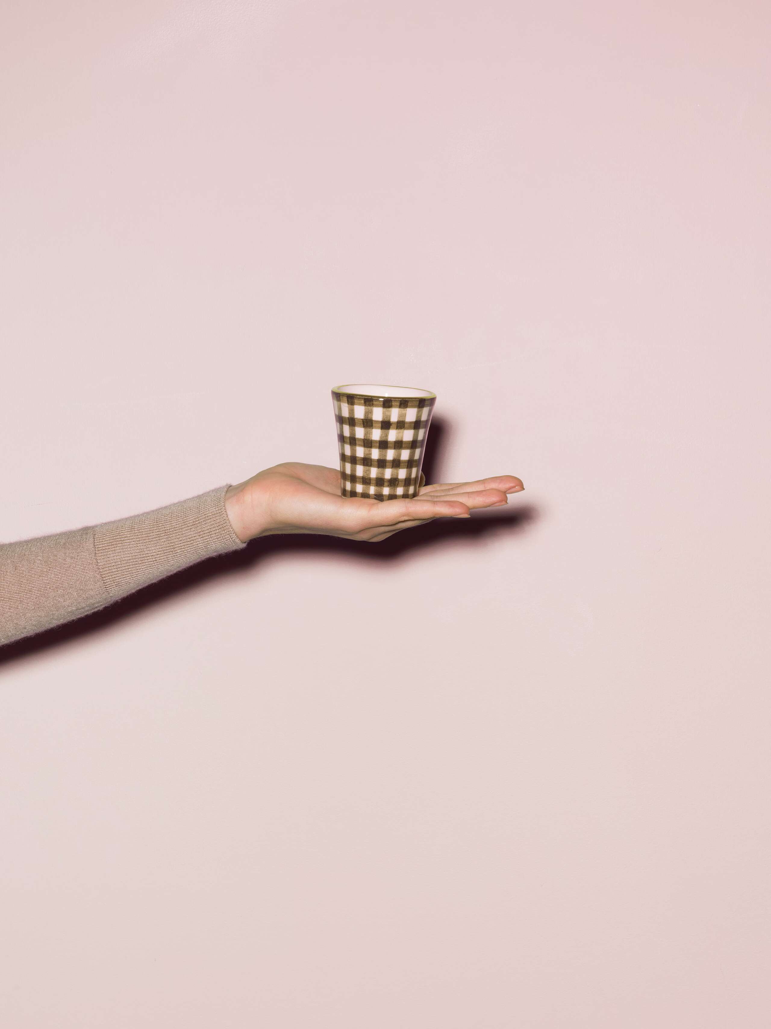Picture of a hand made and hand printed espresso cup made of ceramic featuring a beige vichy check pattern