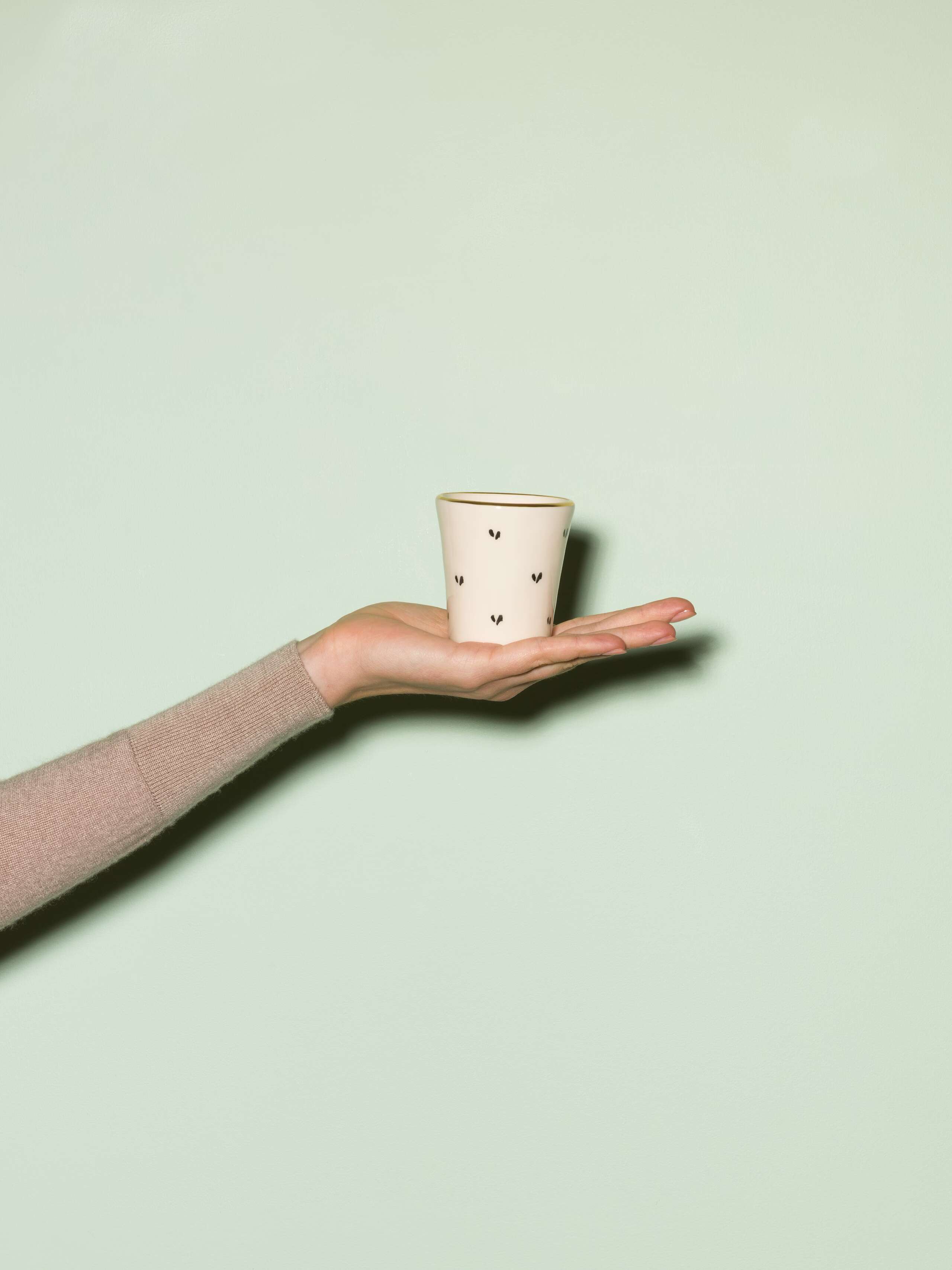 Picture of a hand made and hand printed espresso cup made of ceramic featuring a hermeline pattern