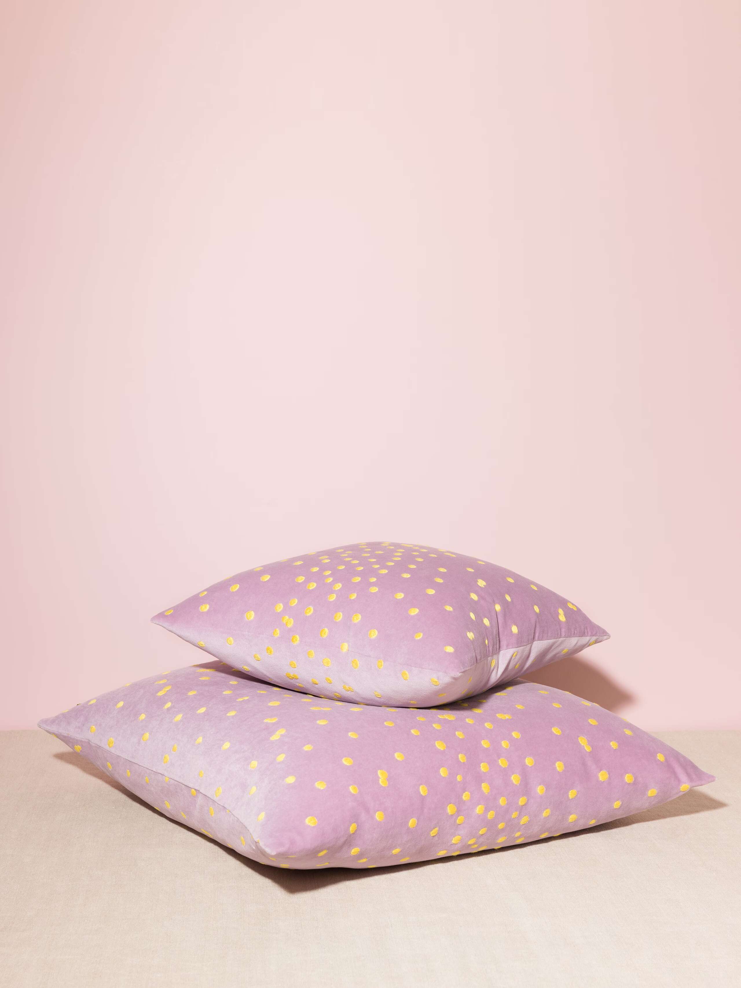 Picture of two beautiful pillow covers in light lilac featuring yellow hand embroidered dots