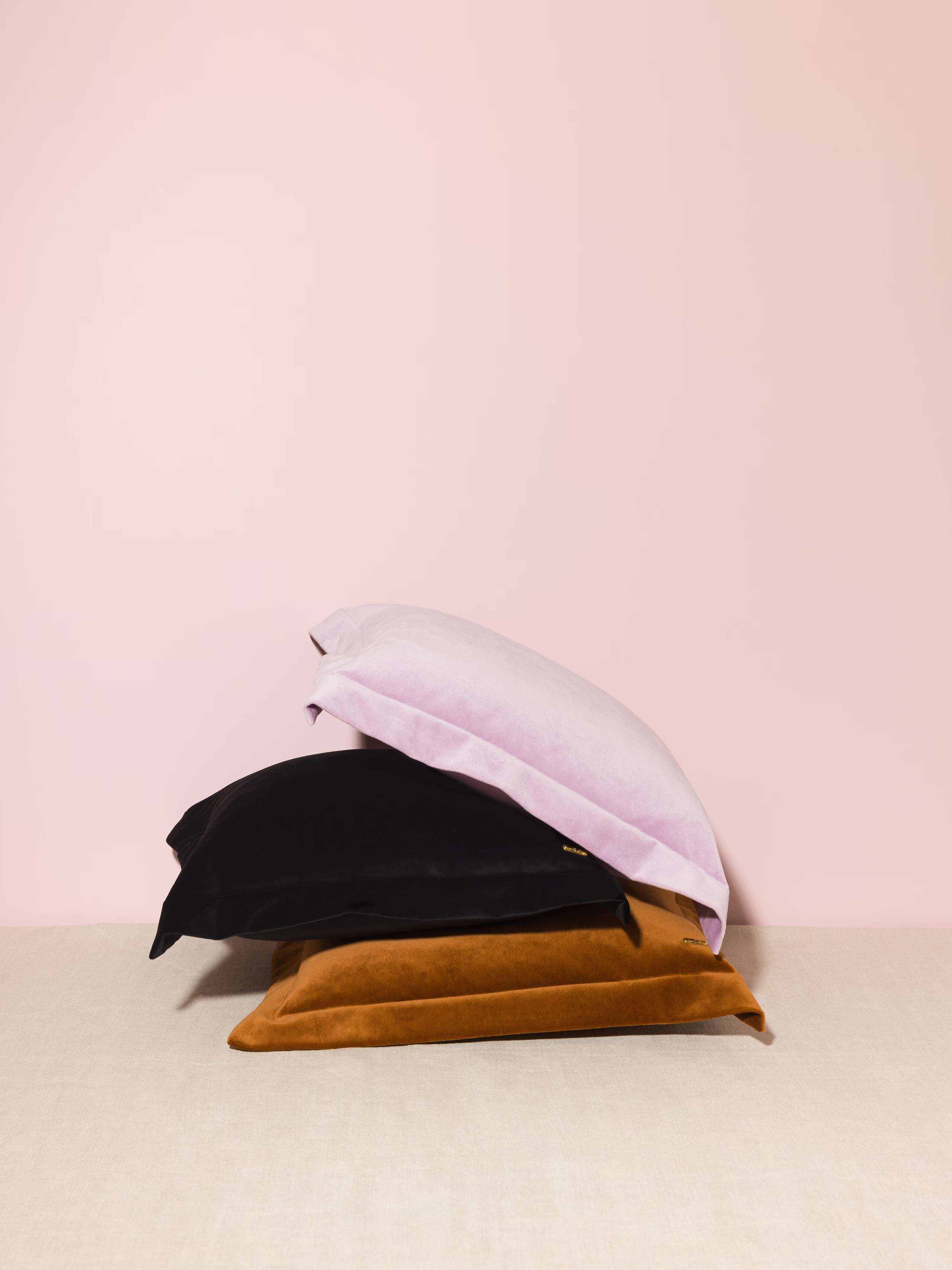 Picture of three beautiful pillow covers made of warm brown, light lilac and black cotton velvet