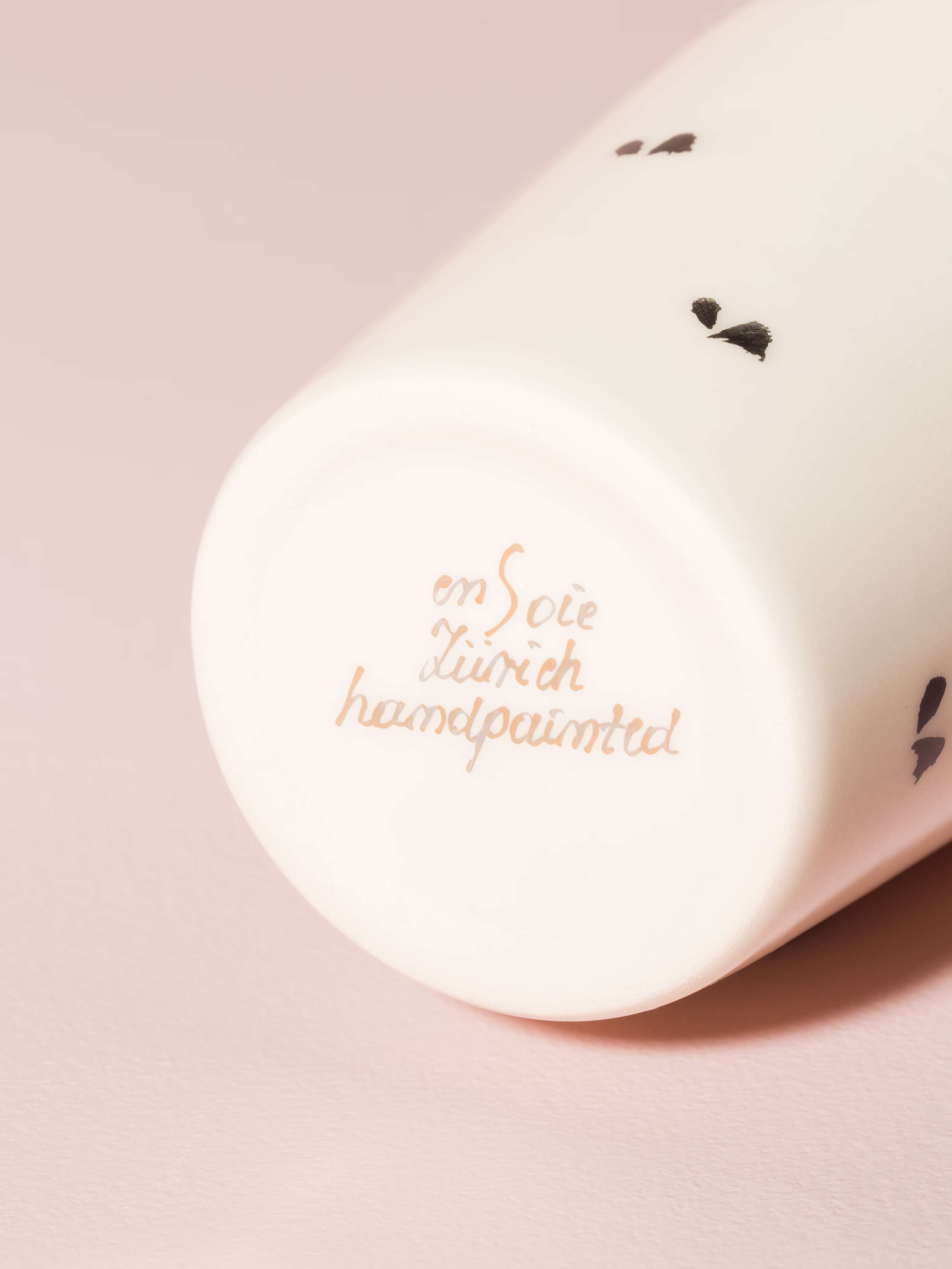 Picture of a detail of a coffee cup featuring the text "enSoie Zurich handpainted"