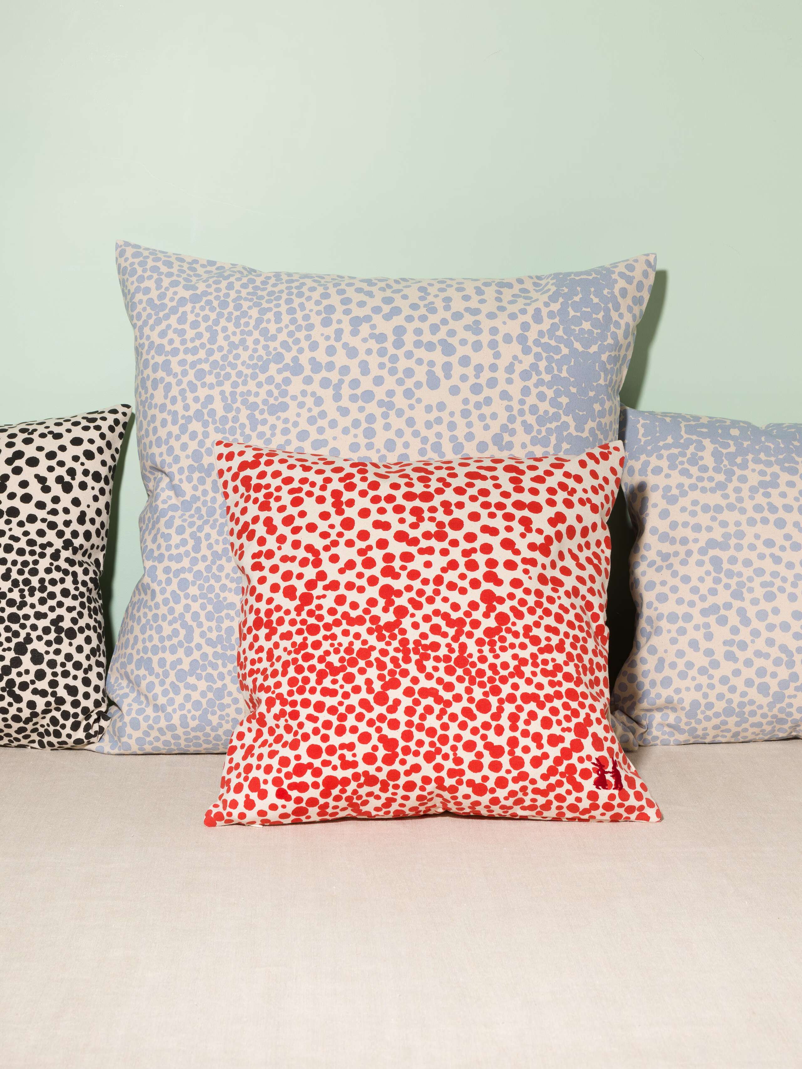 Picture of four pillow covers made of cotton canvas featuring pink, black and red dots