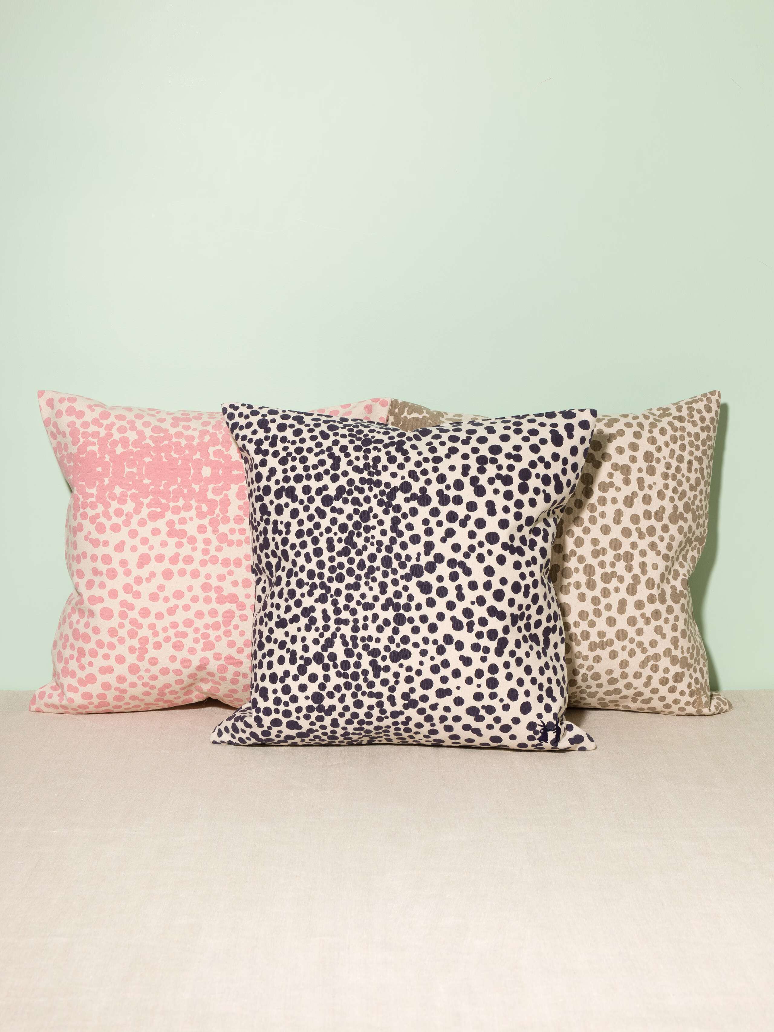 Picture of three pillow covers made of cotton canvas featuring light blue, pink and beige dots