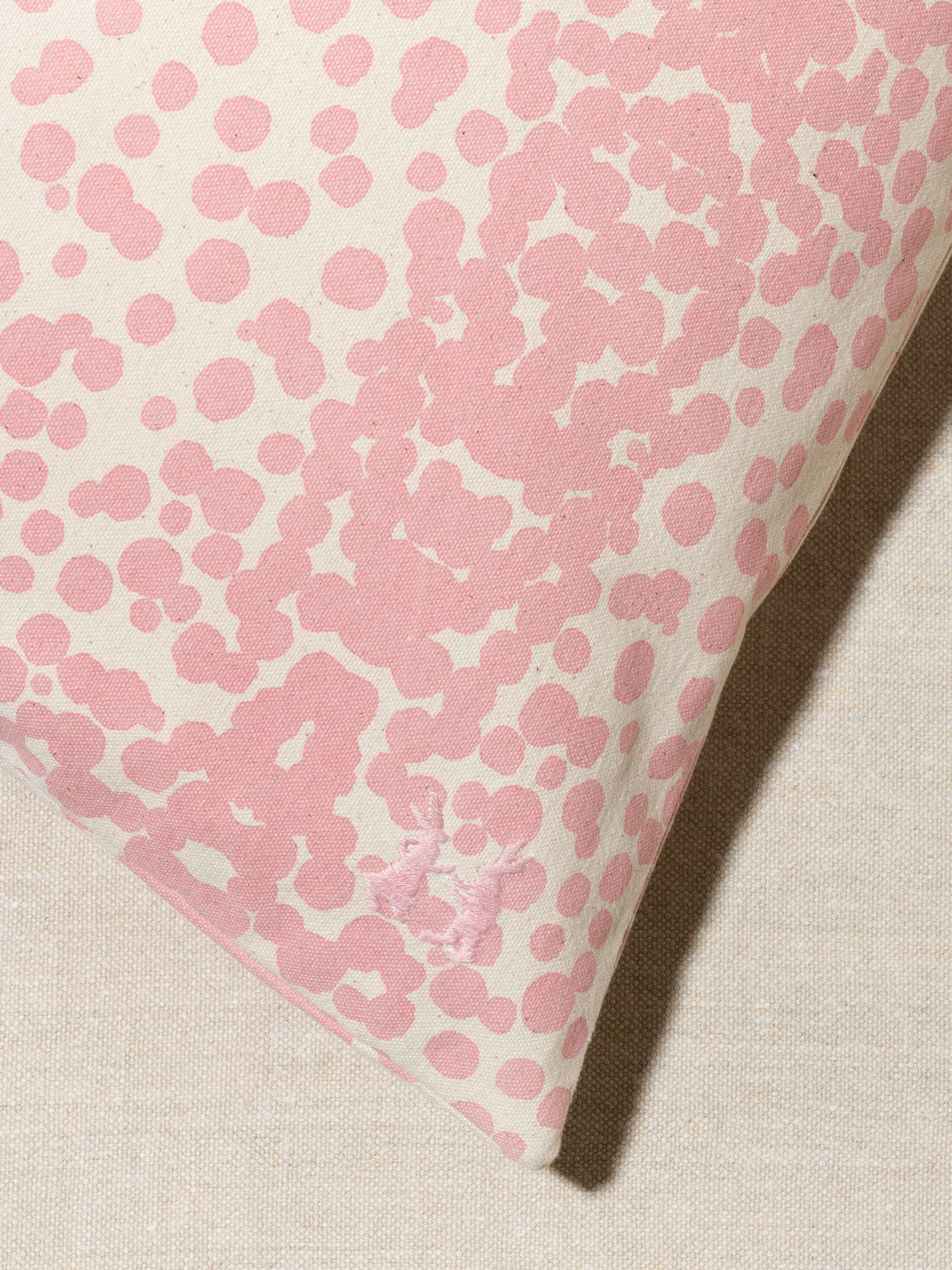 Picture of a detail of a pillow cover made from cotton canvas featuring pink dots
