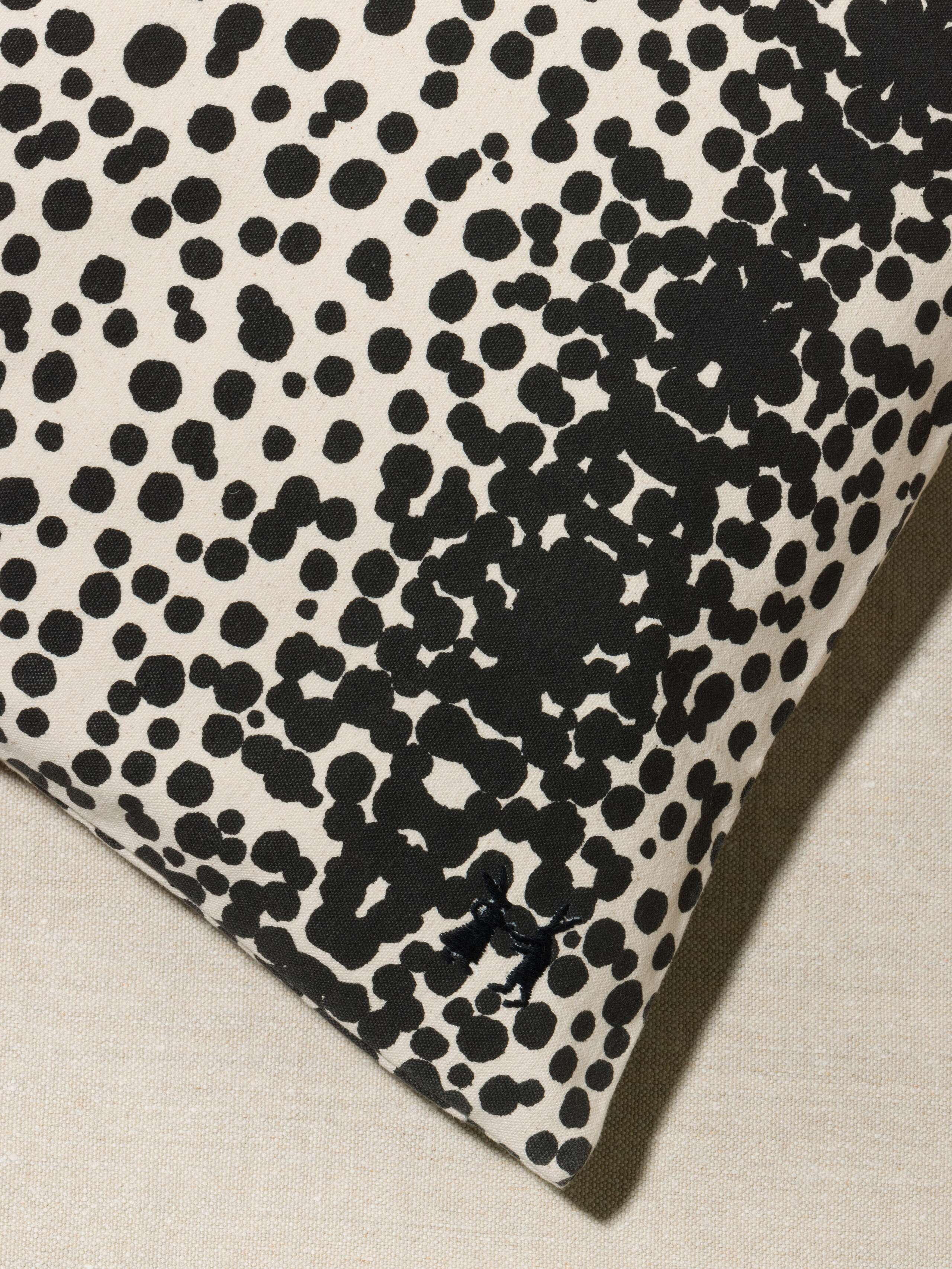 Picture of a detail of a pillow cover made from cotton canvas featuring black dots