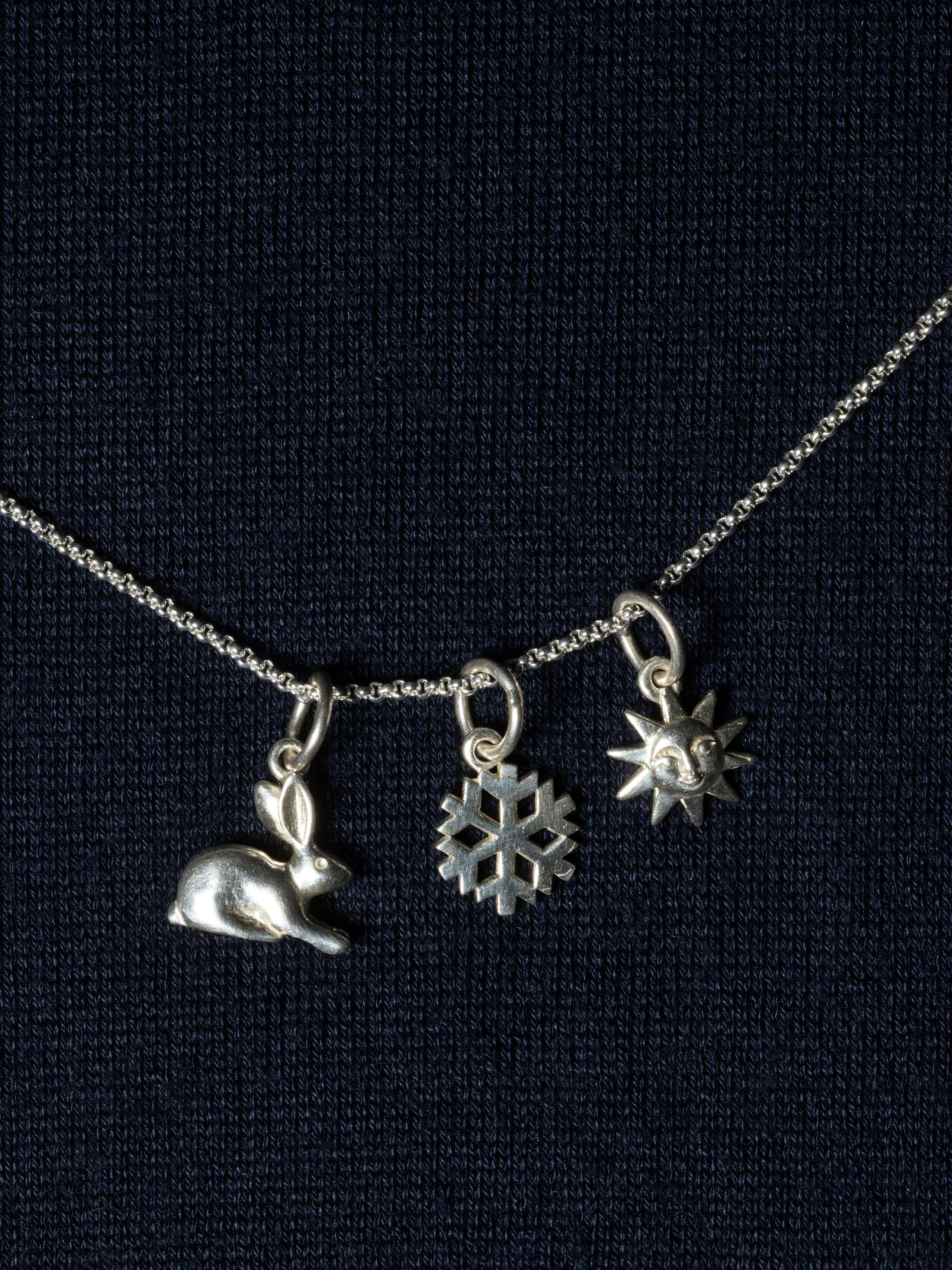 Picture of three beautiful silver pendants (rabbit, snowflake, sun)