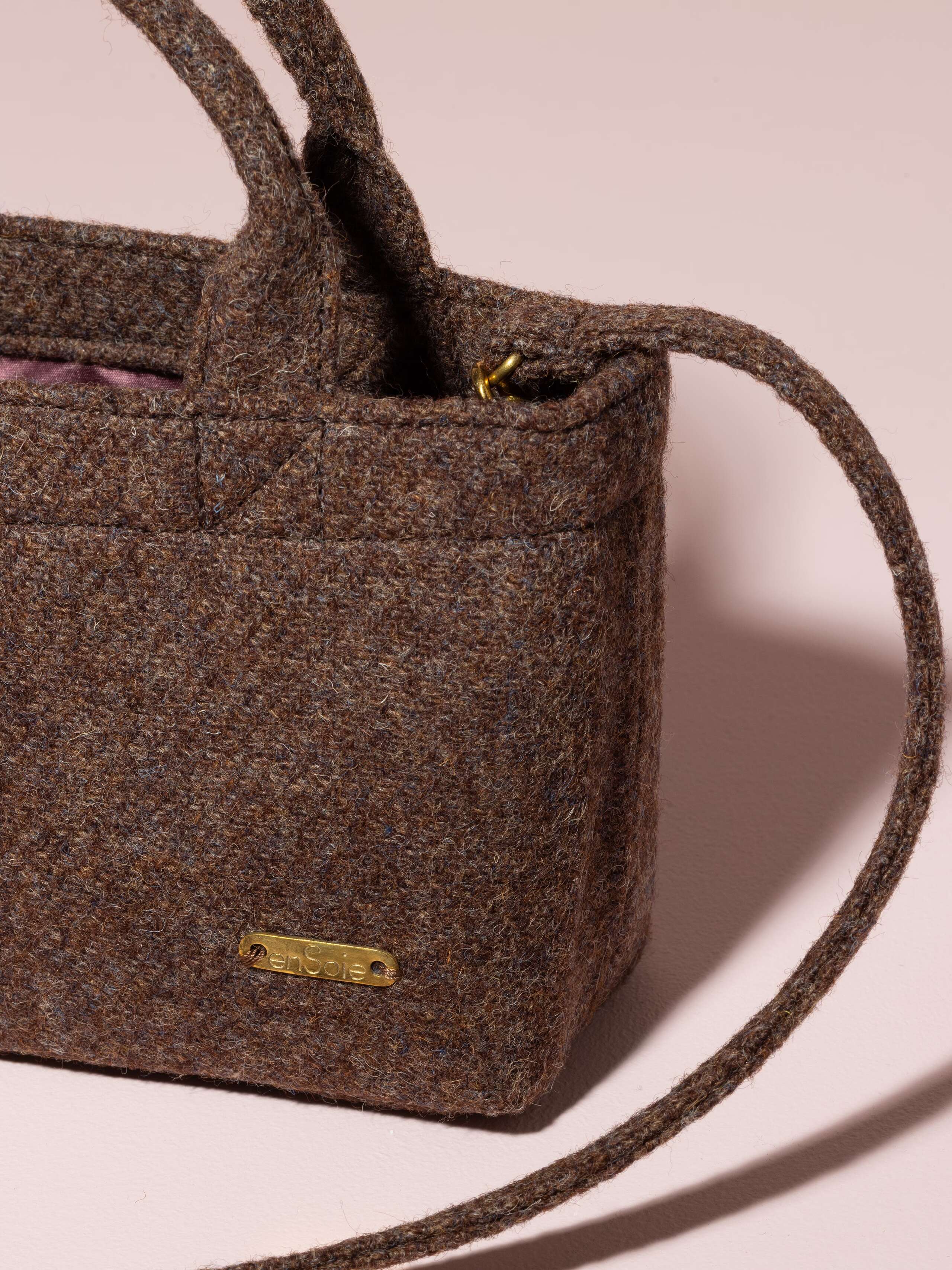 Picture of a detail of a small handbag made of brown wool fabric