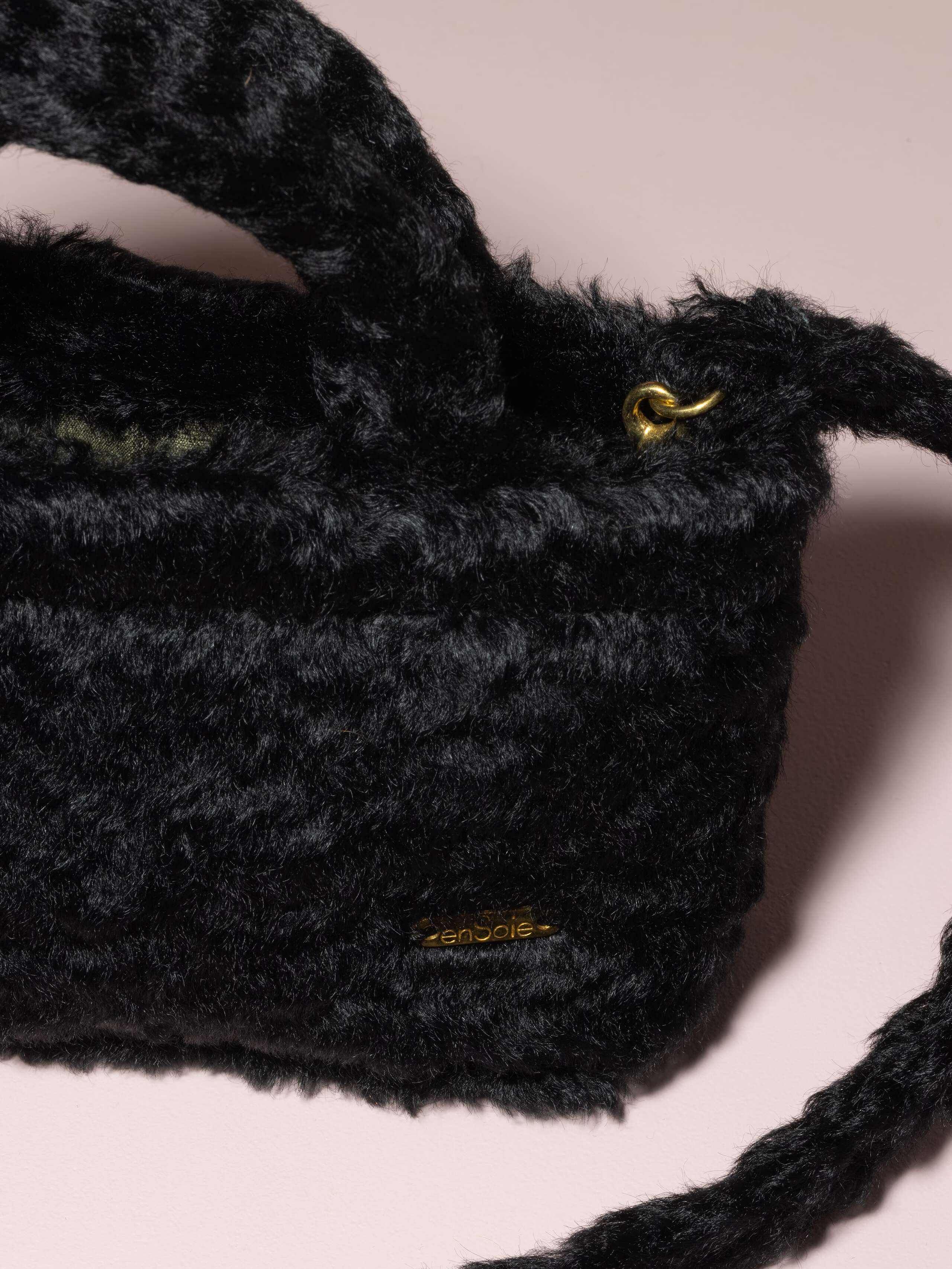 Picture of a detail of a small handbag made of black mohair fabric