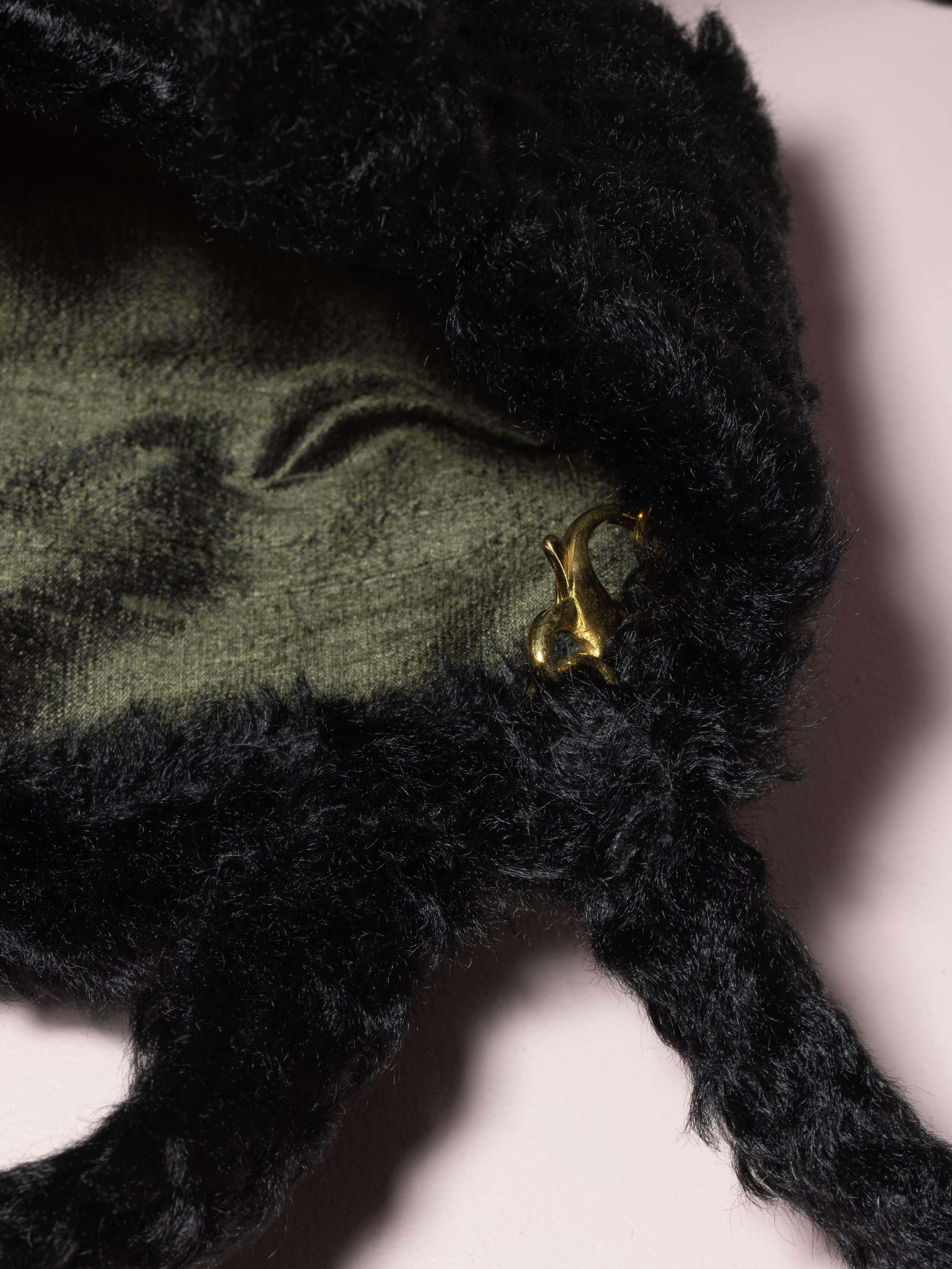 Picture of a detail of a small handbag made of black mohair fabric