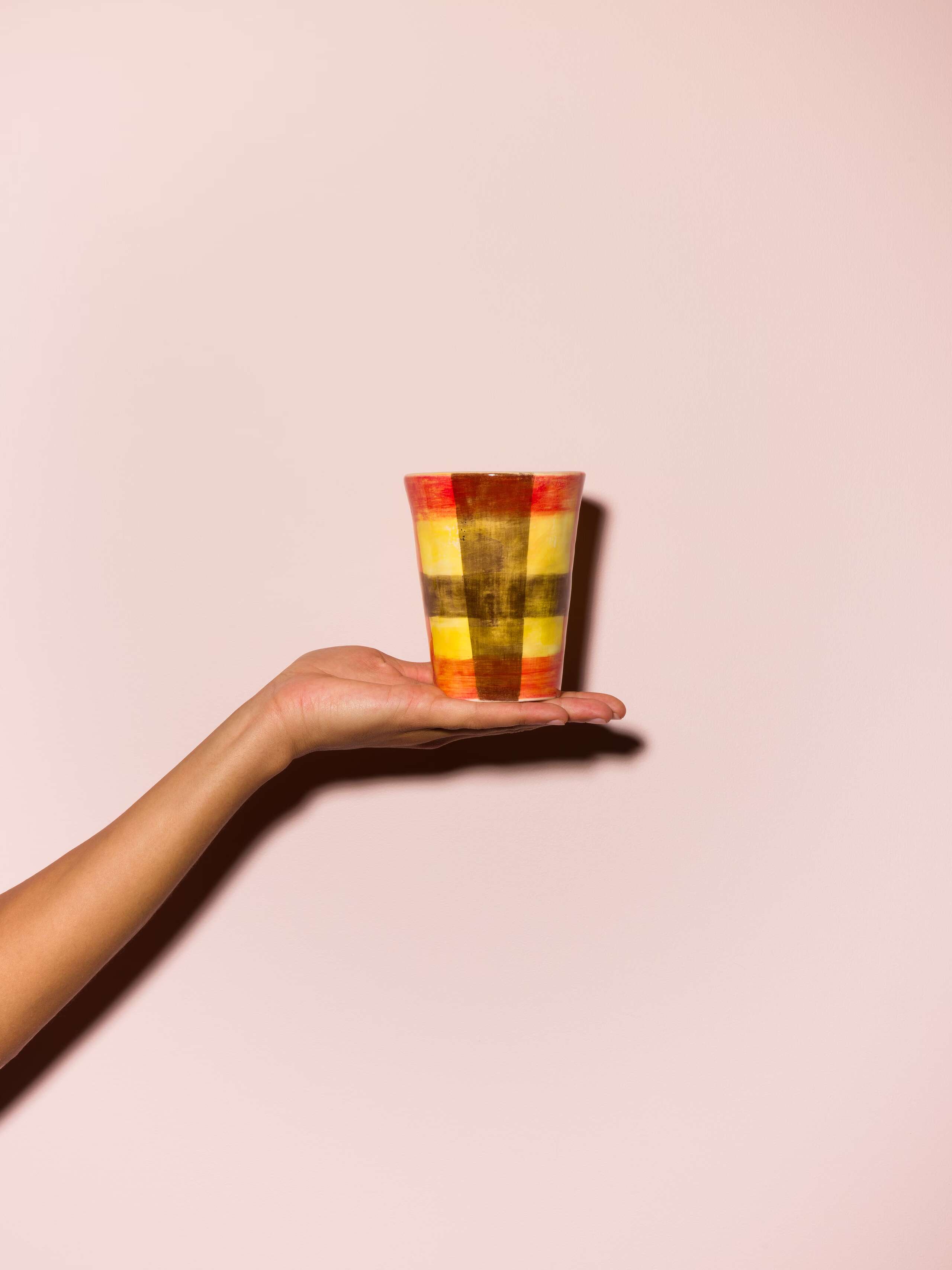 Picture of a hand holding a colourful cup