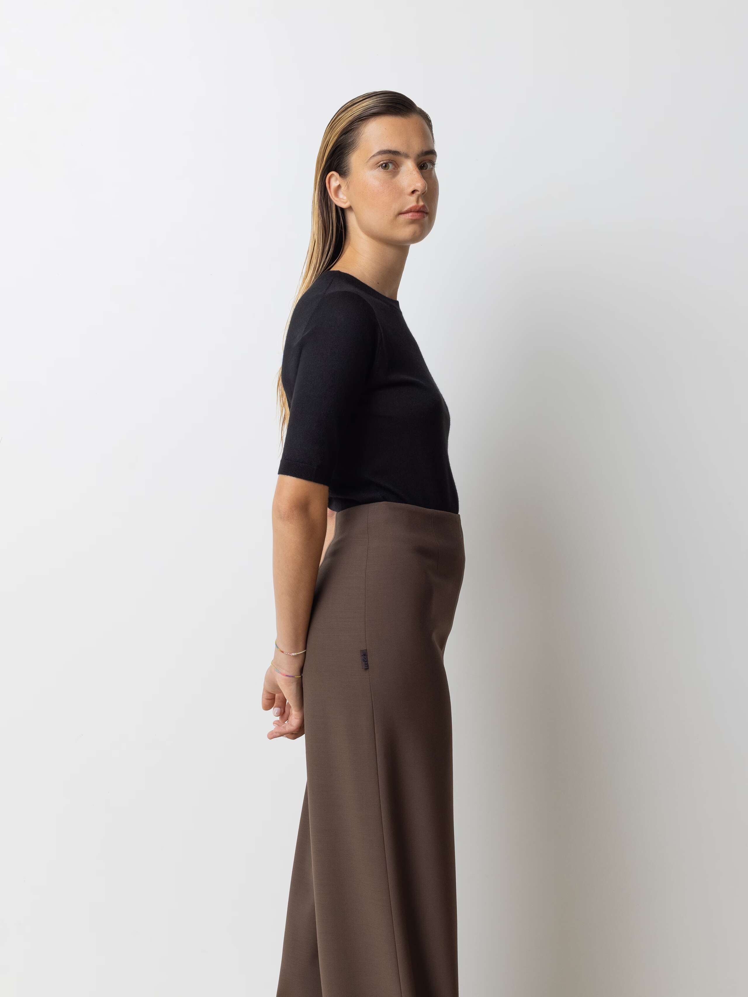 Picture of a female model wearing a classic black turtleneck in combination with brown wool pants