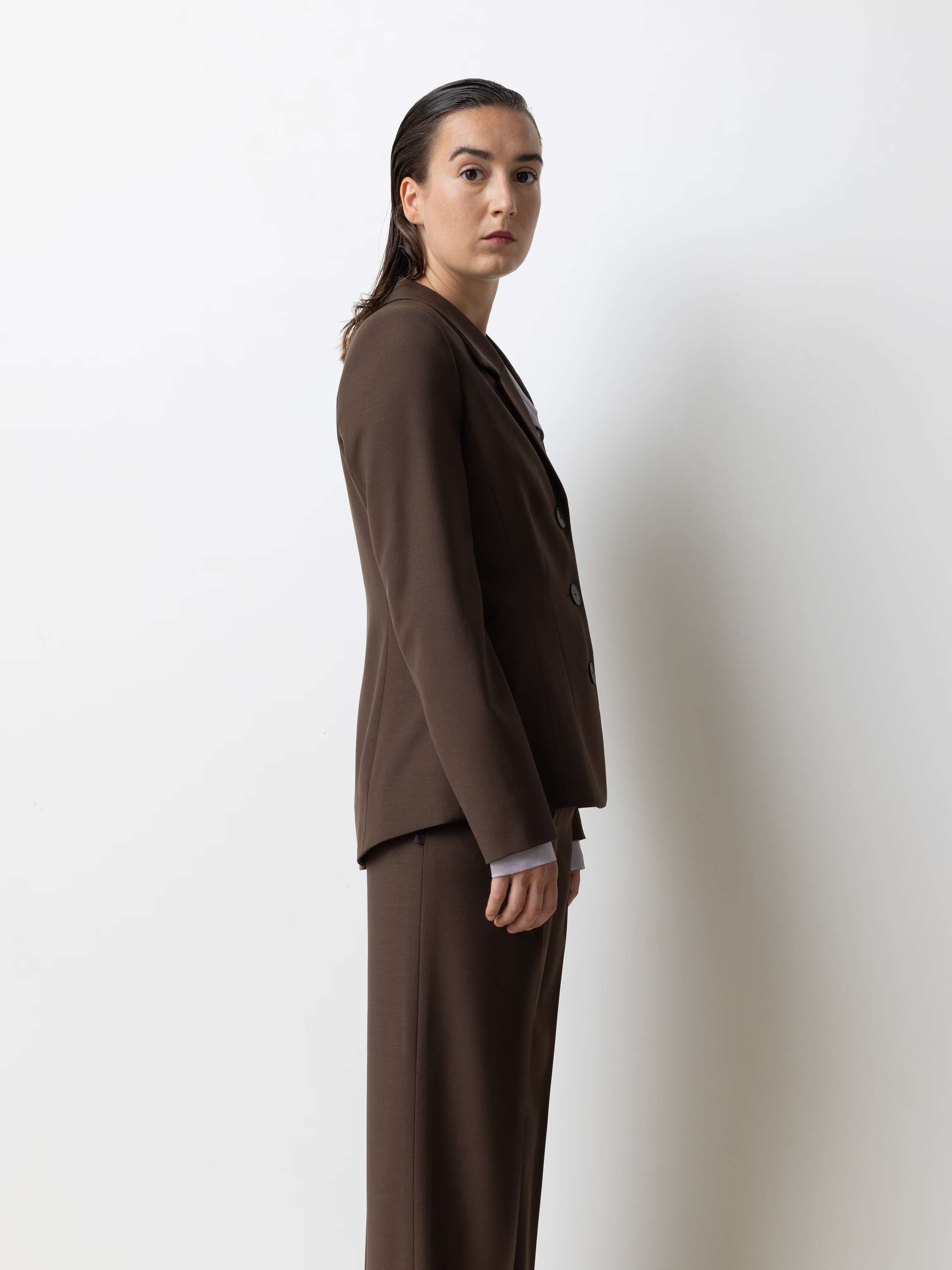 Picture of a model wearing a brown cool wool blazer in combination with brown cool wool pants and a lavender coloured silk blouse