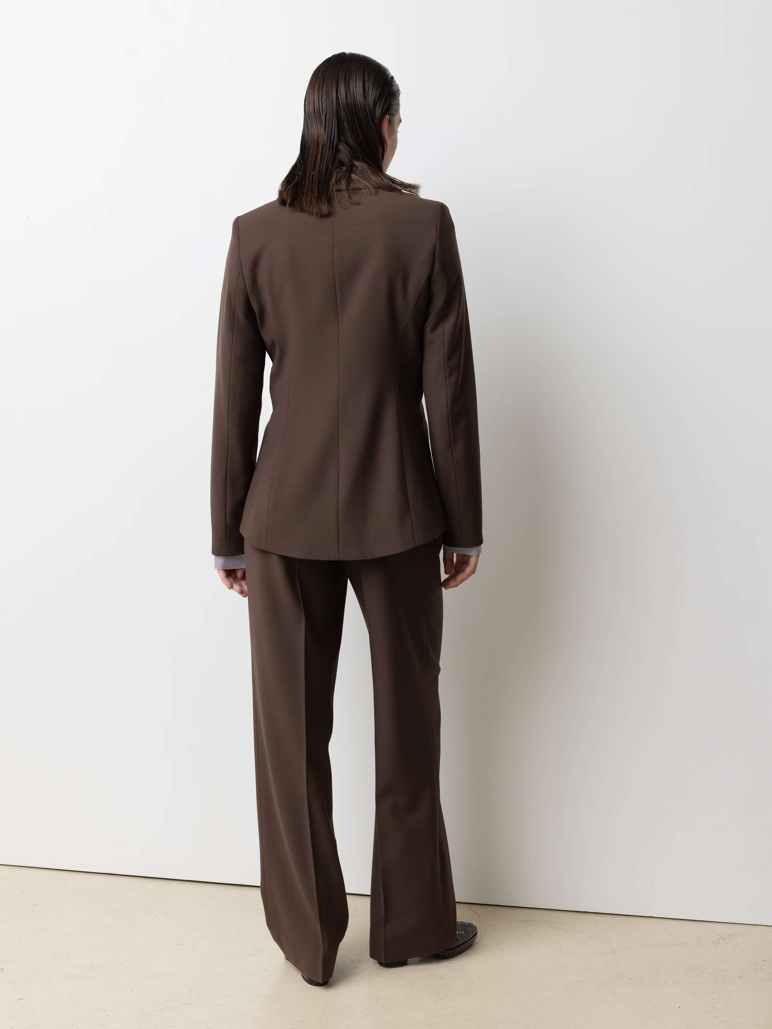 Picture of a model wearing a brown cool wool blazer in combination with brown cool wool pants and a lavender coloured silk blouse