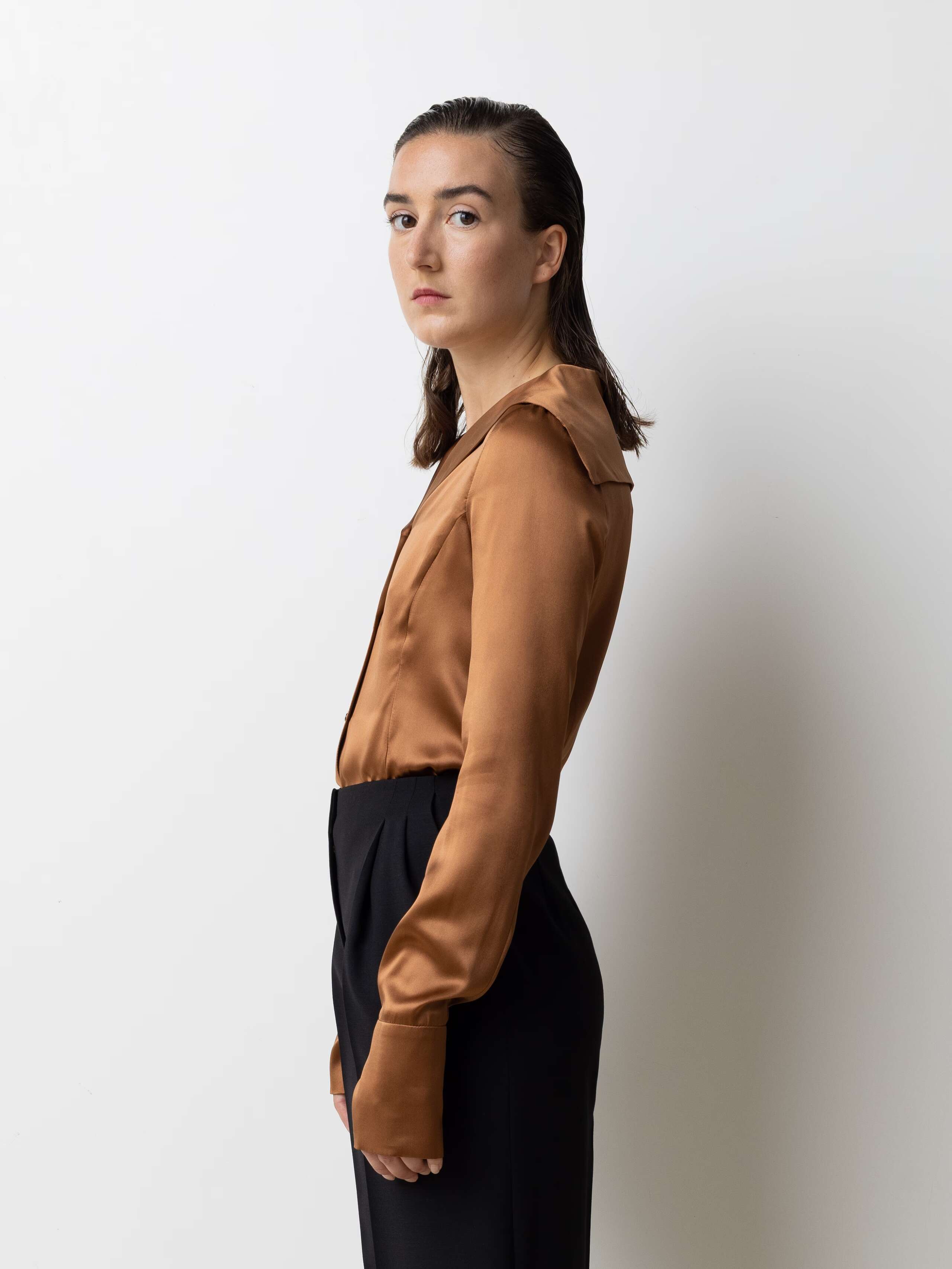 Picture of a female model wearing a brown shiny silk blouse