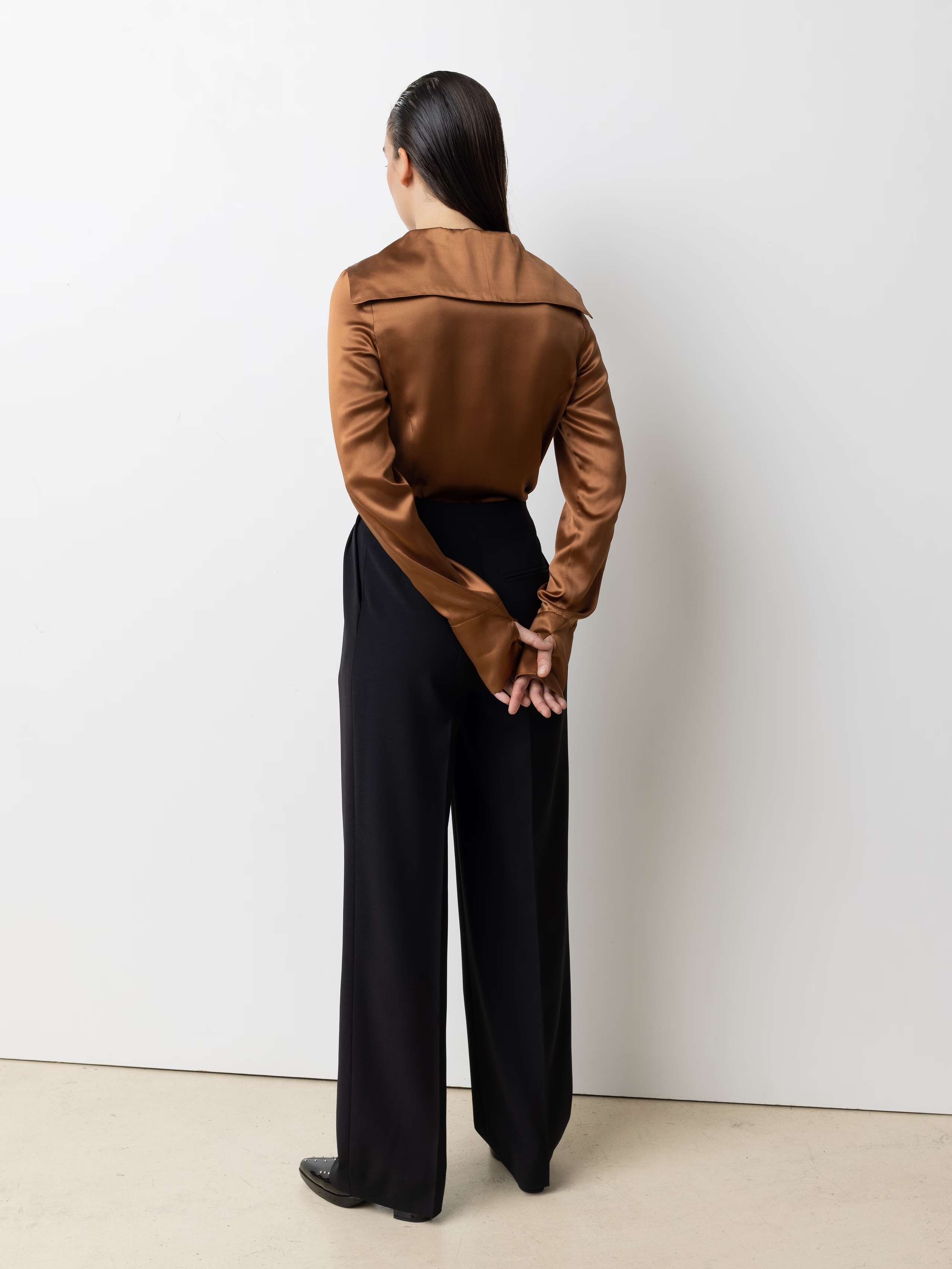 Picture of a female model wearing a brown satin silk blouse