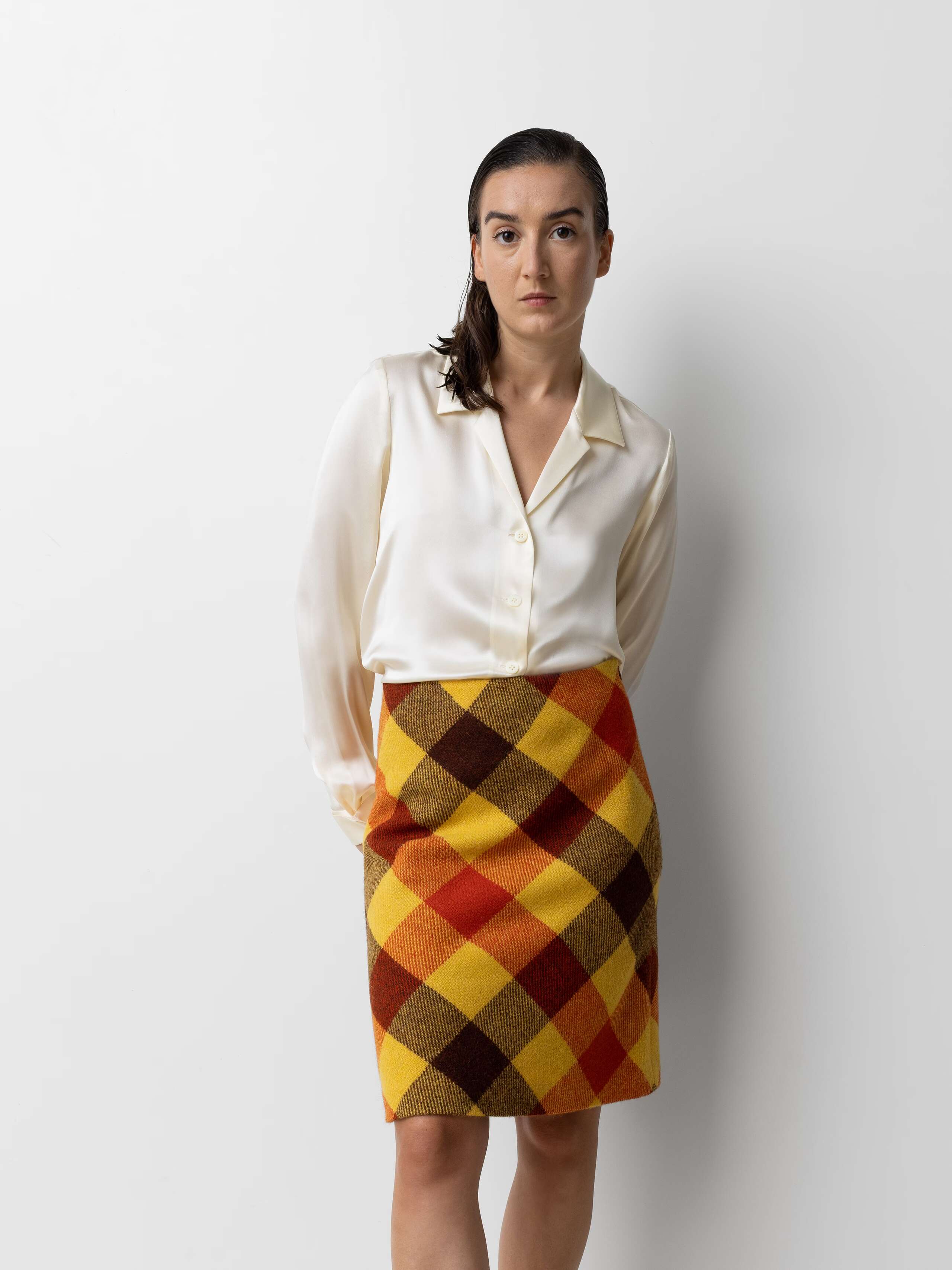 Picture of a female model wearing a colourful wool skirt in combination with a beige blouse
