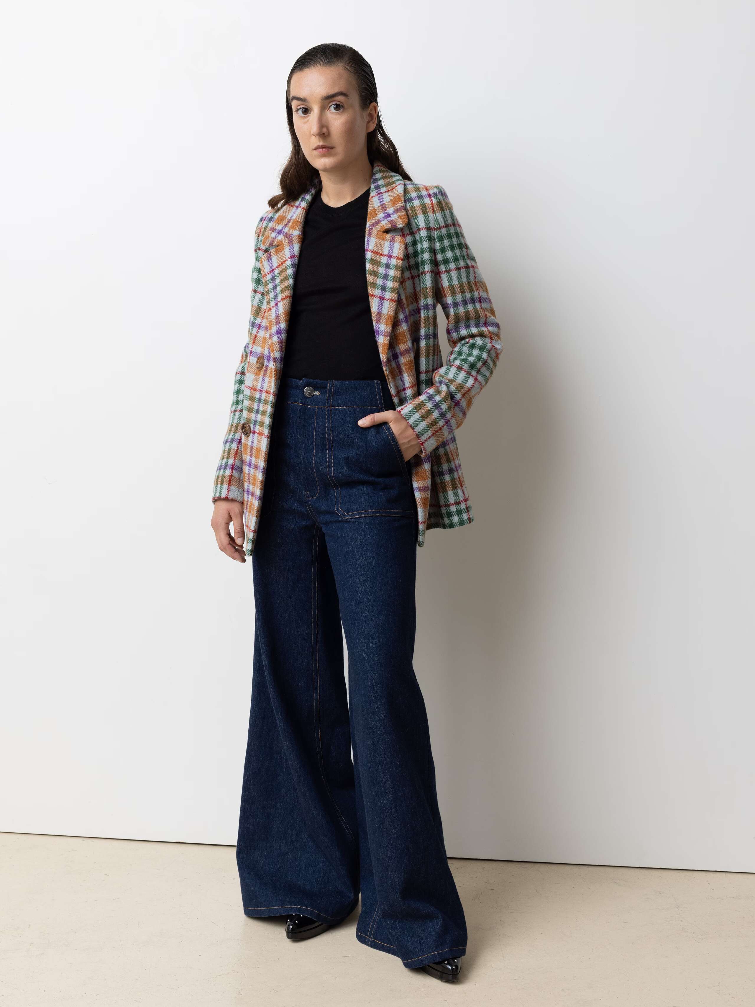 Picture of a female model wearing a colourful wool blazer in combination with a wide leg jeans