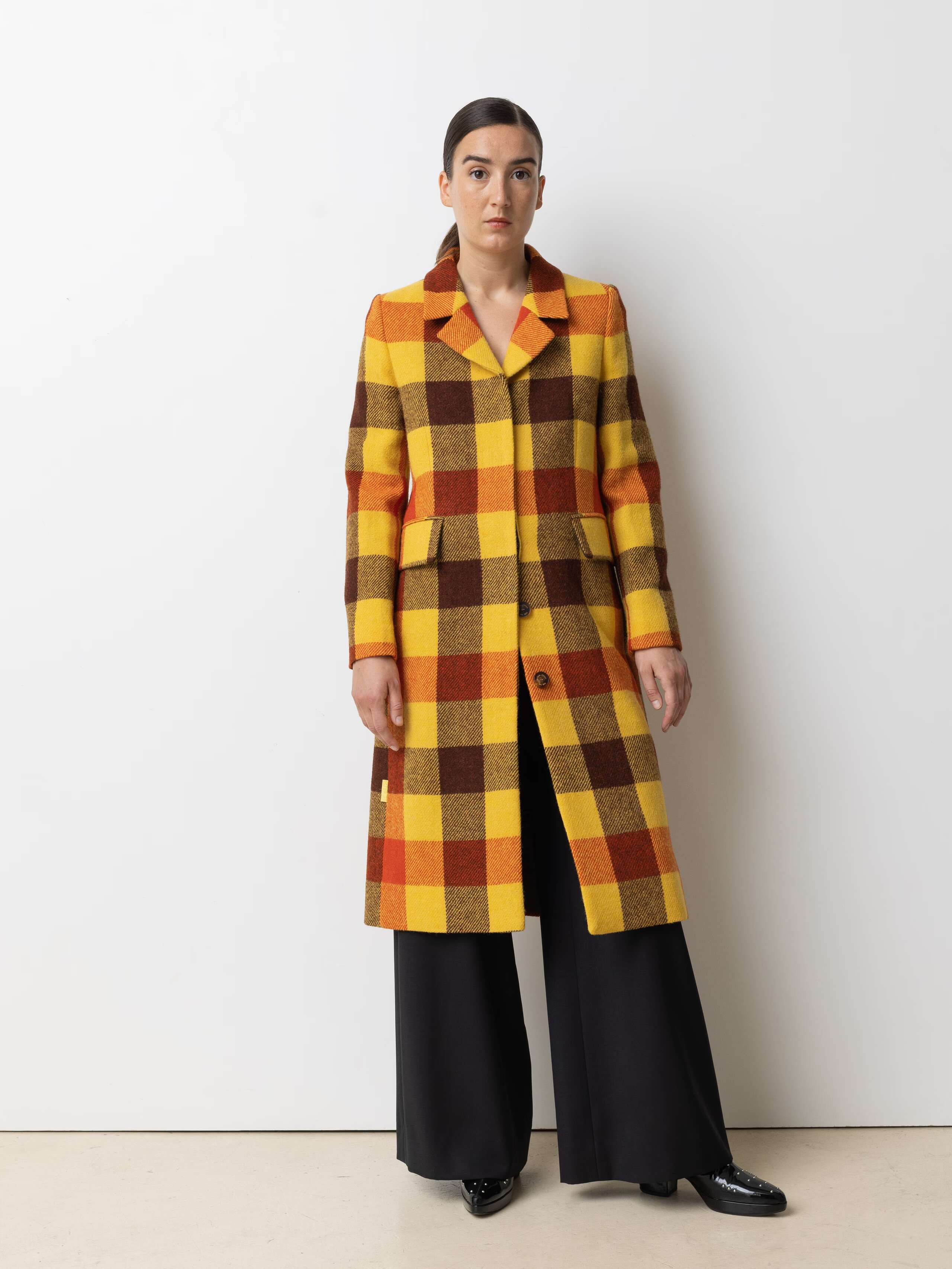 Picture of a female model wearing a colourful winter coat made from Harris Tweed
