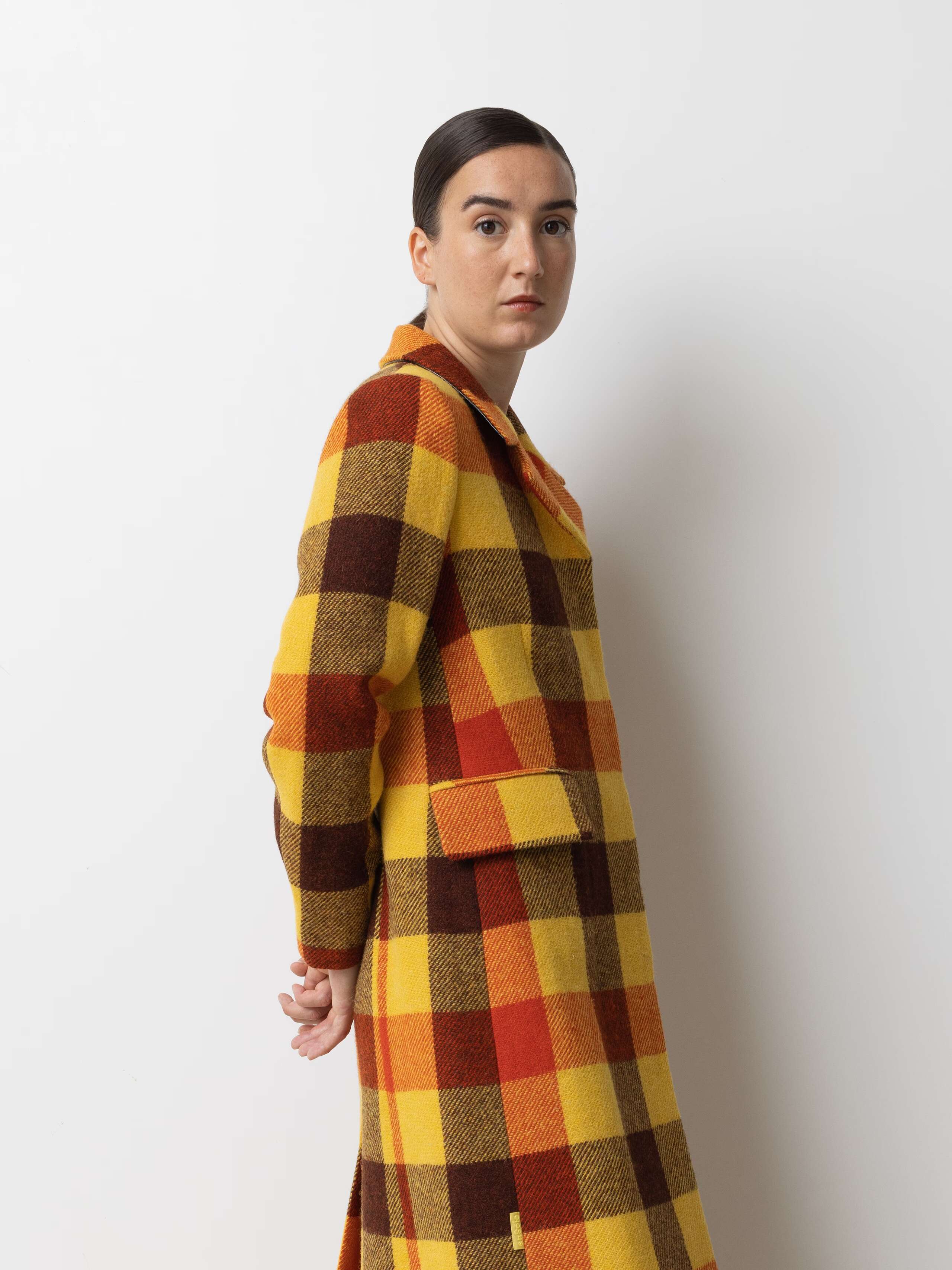 Picture of a female model wearing a colourful winter coat made from Harris Tweed