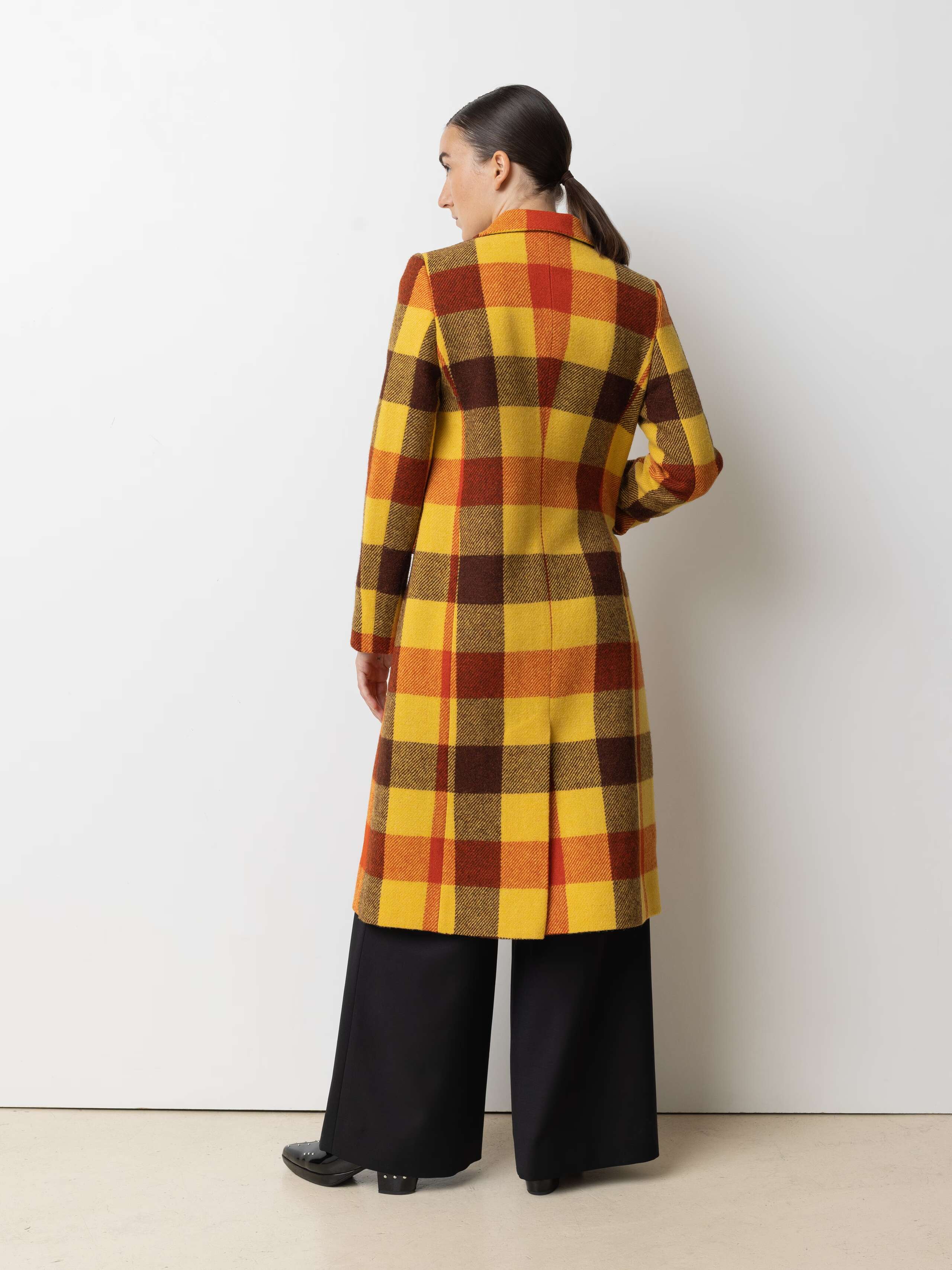 Picture of a female model wearing a colourful winter coat made from Harris Tweed