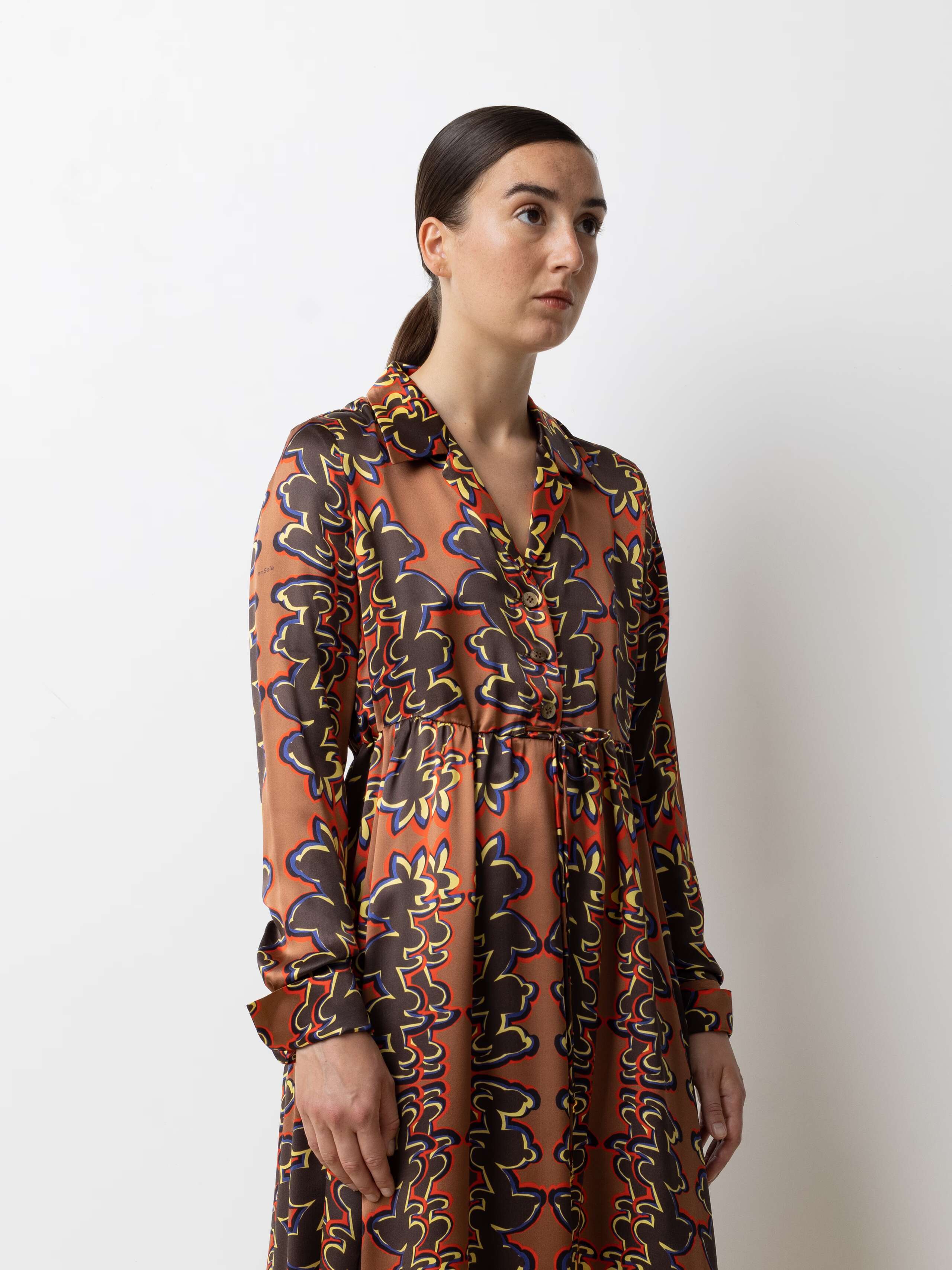 Picture of a female model wearing a beautiful silk dress featuring a nice rabbit print in red, yellow and bleu shades