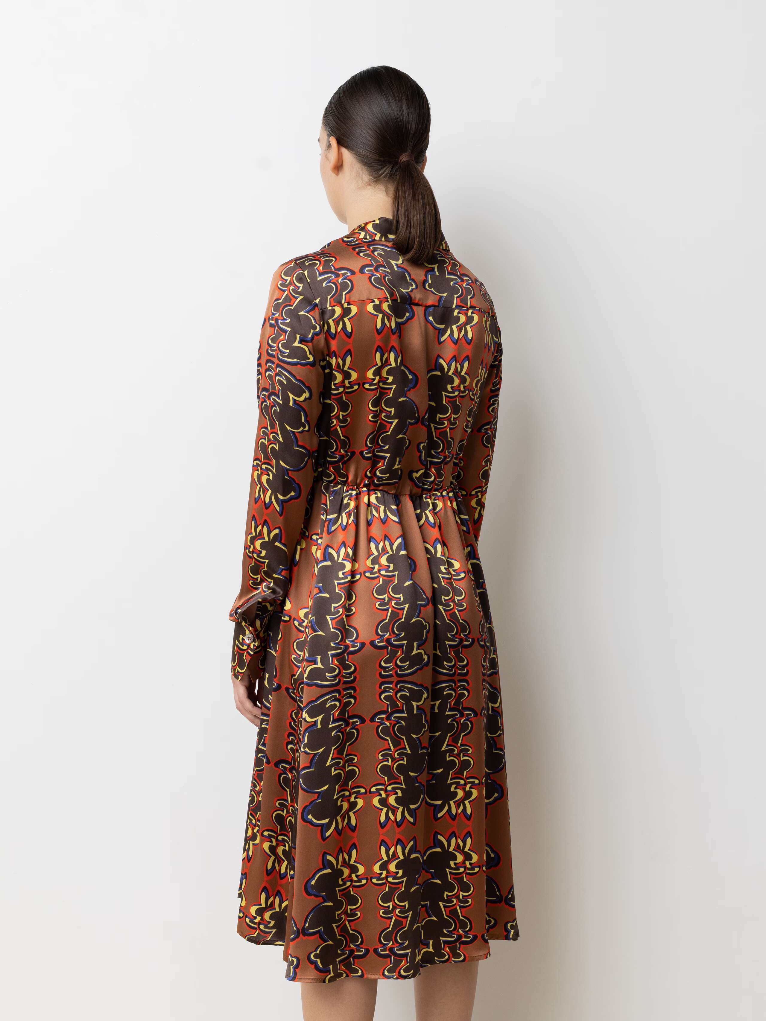 Picture of a female model wearing a beautiful silk dress featuring a nice rabbit print in red, yellow and bleu shades