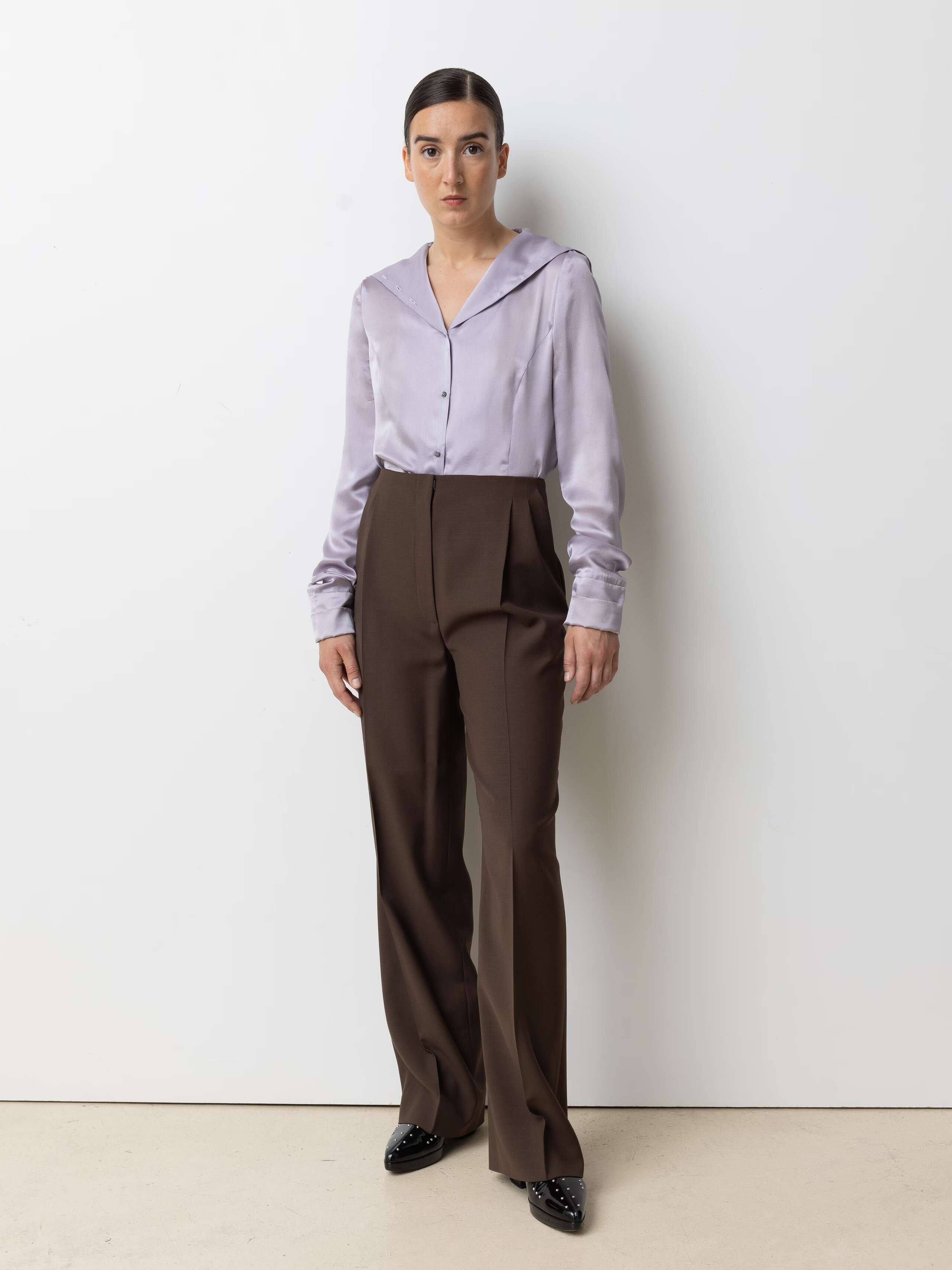 Picture of a model wearing a lavender coloured silk blouse in combination with brown cool wool pant