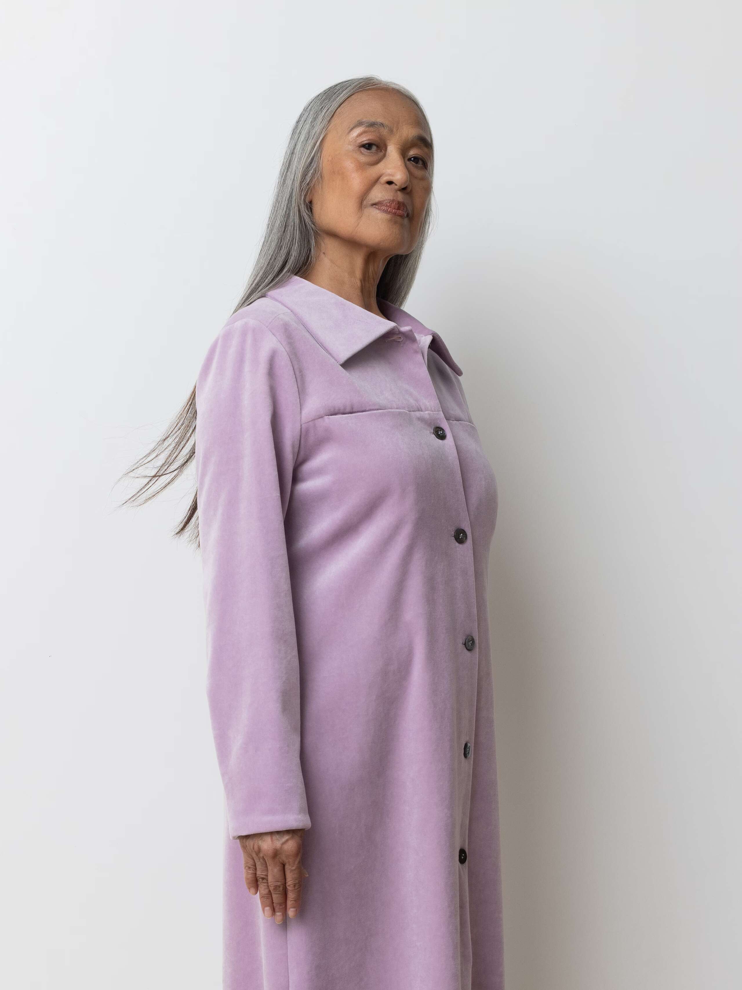 Picture of a female model wearing a long velvet dress in a delicate lavender shade