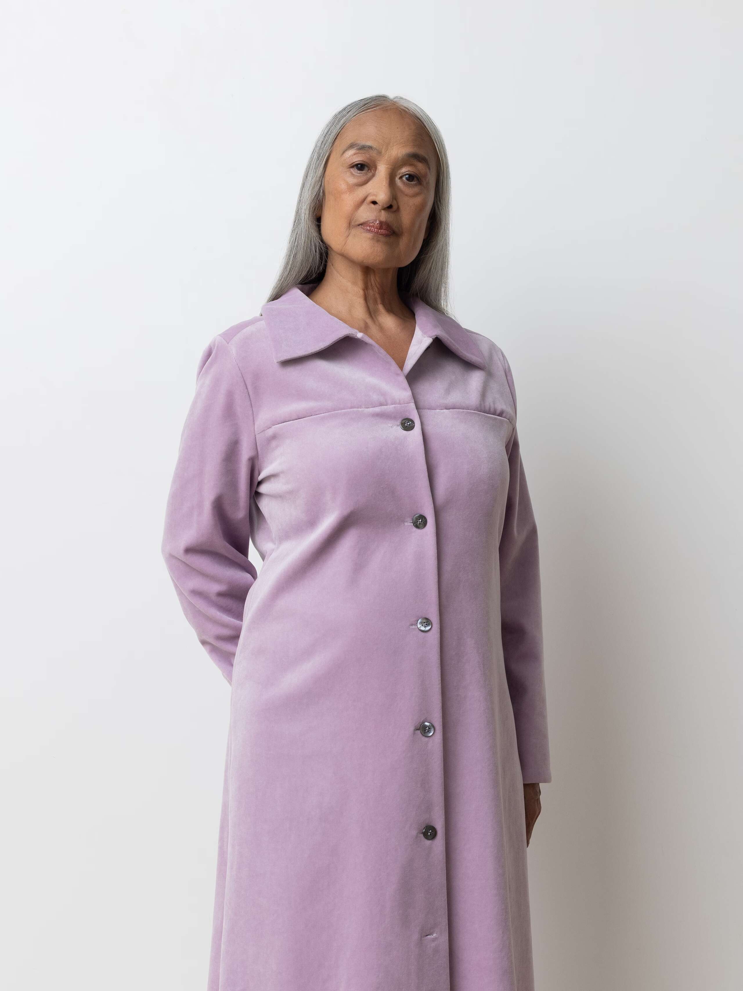 Picture of a female model wearing a long velvet dress in a delicate lavender shade