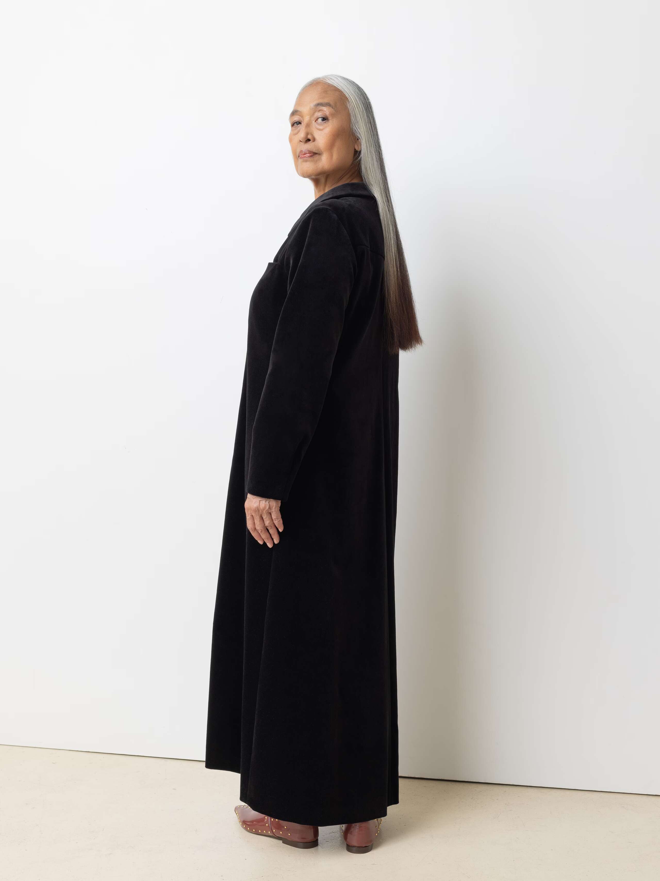 Picture of a female model wearing a long velvet dress in classic black