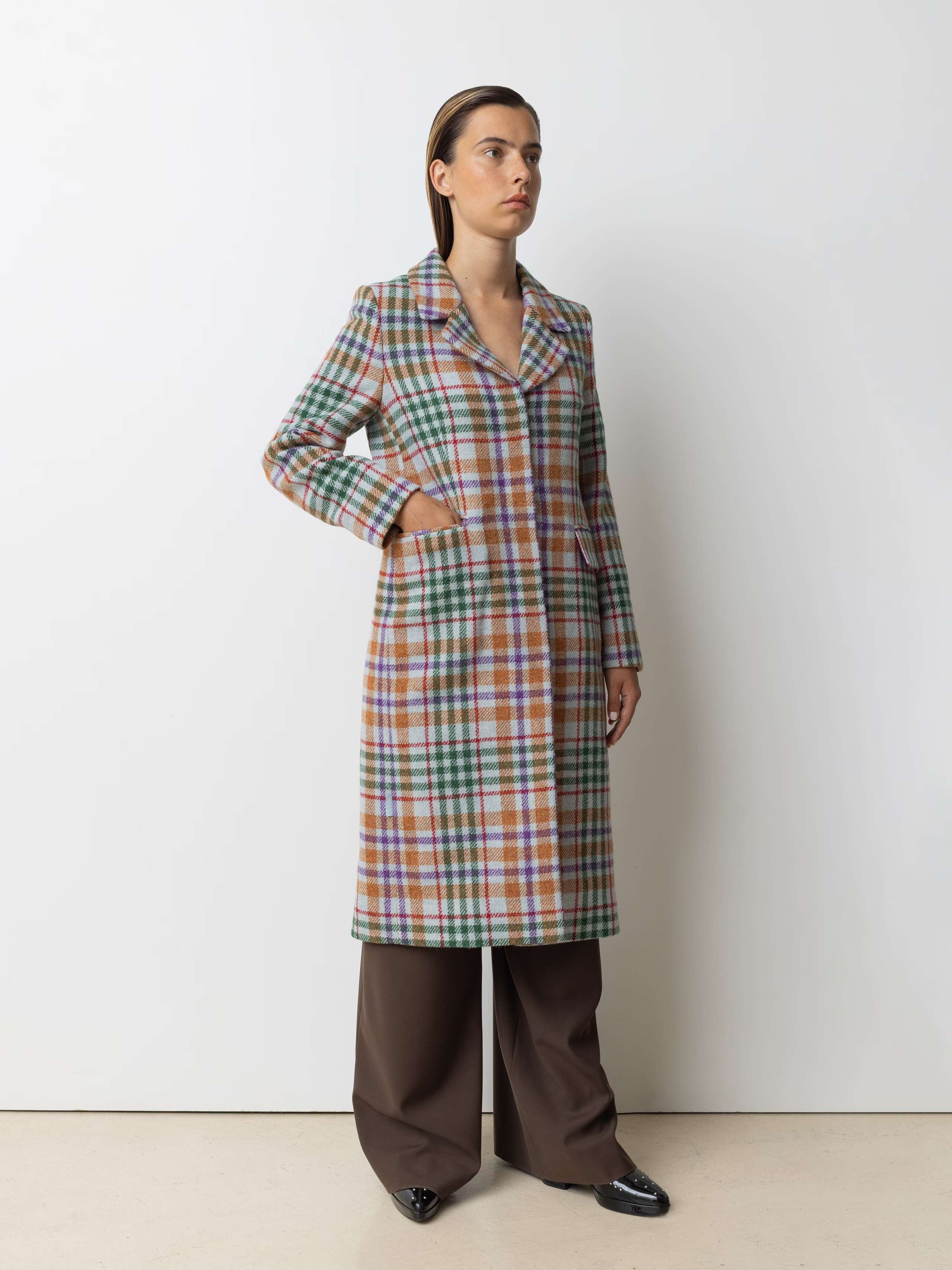 Picture of a female model wearing a colourful winter coat made from Harris Tweed