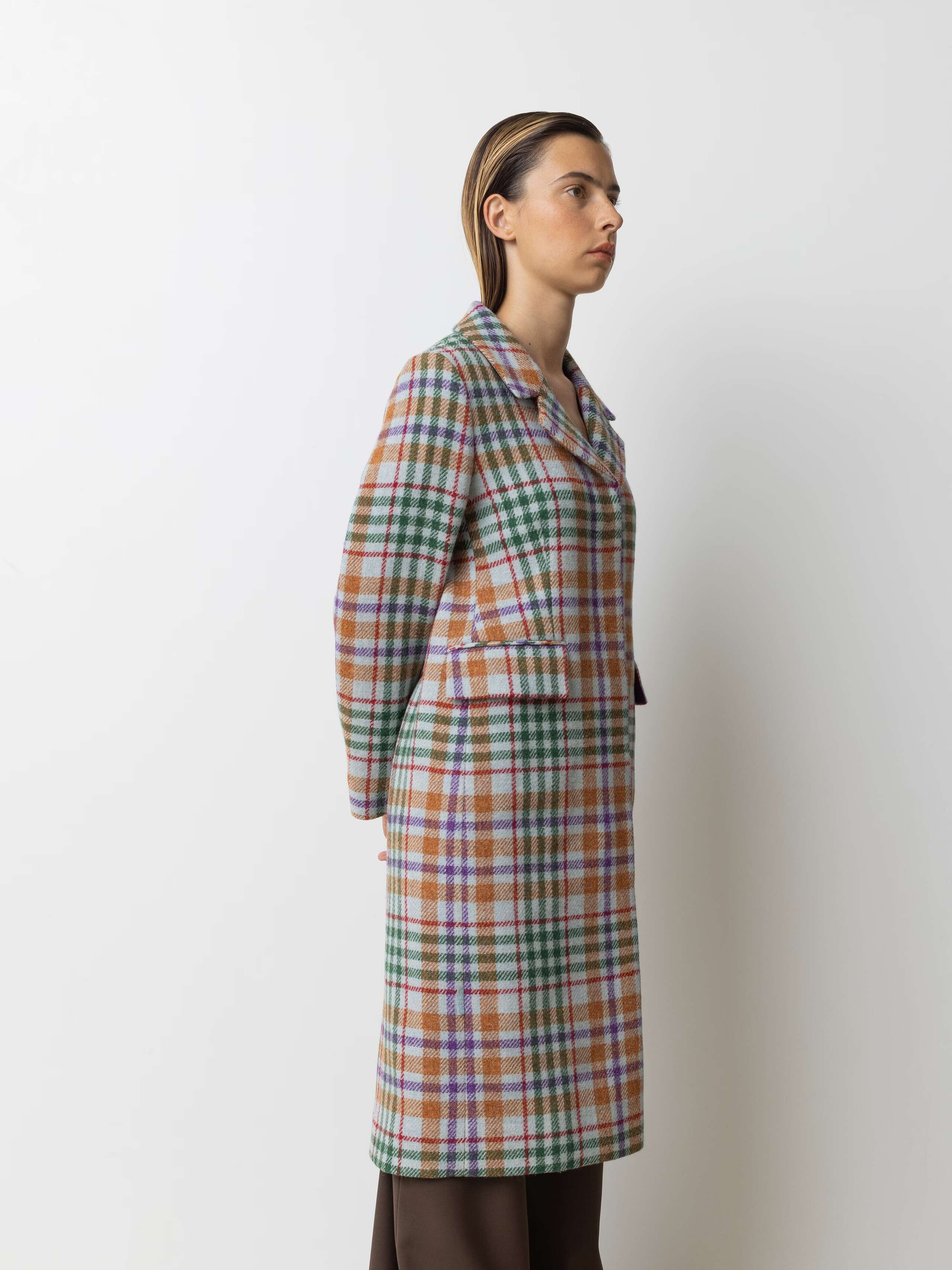 Picture of a female model wearing a colourful winter coat made from Harris Tweed