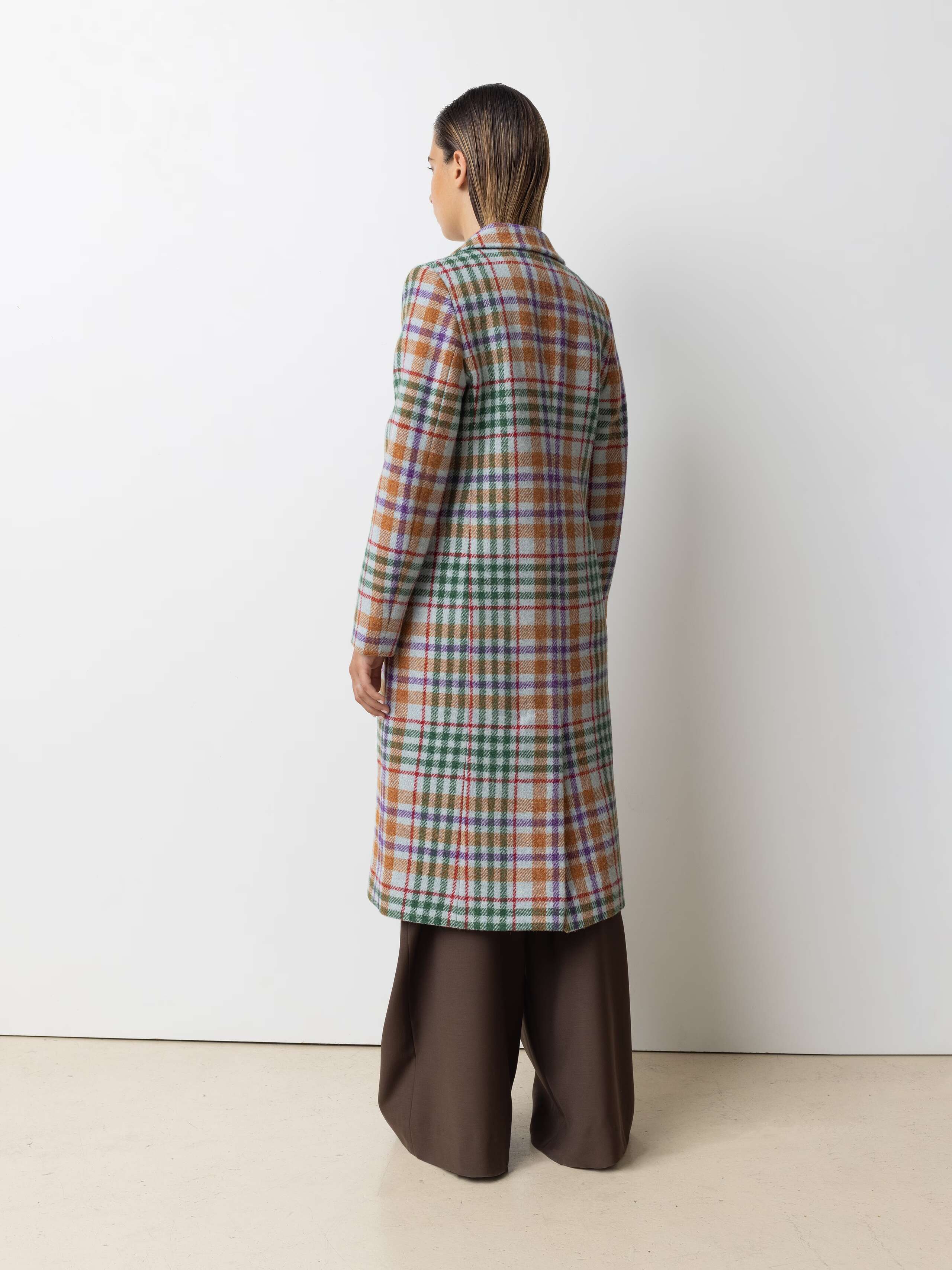 Picture of a female model wearing a colourful winter coat made from Harris Tweed