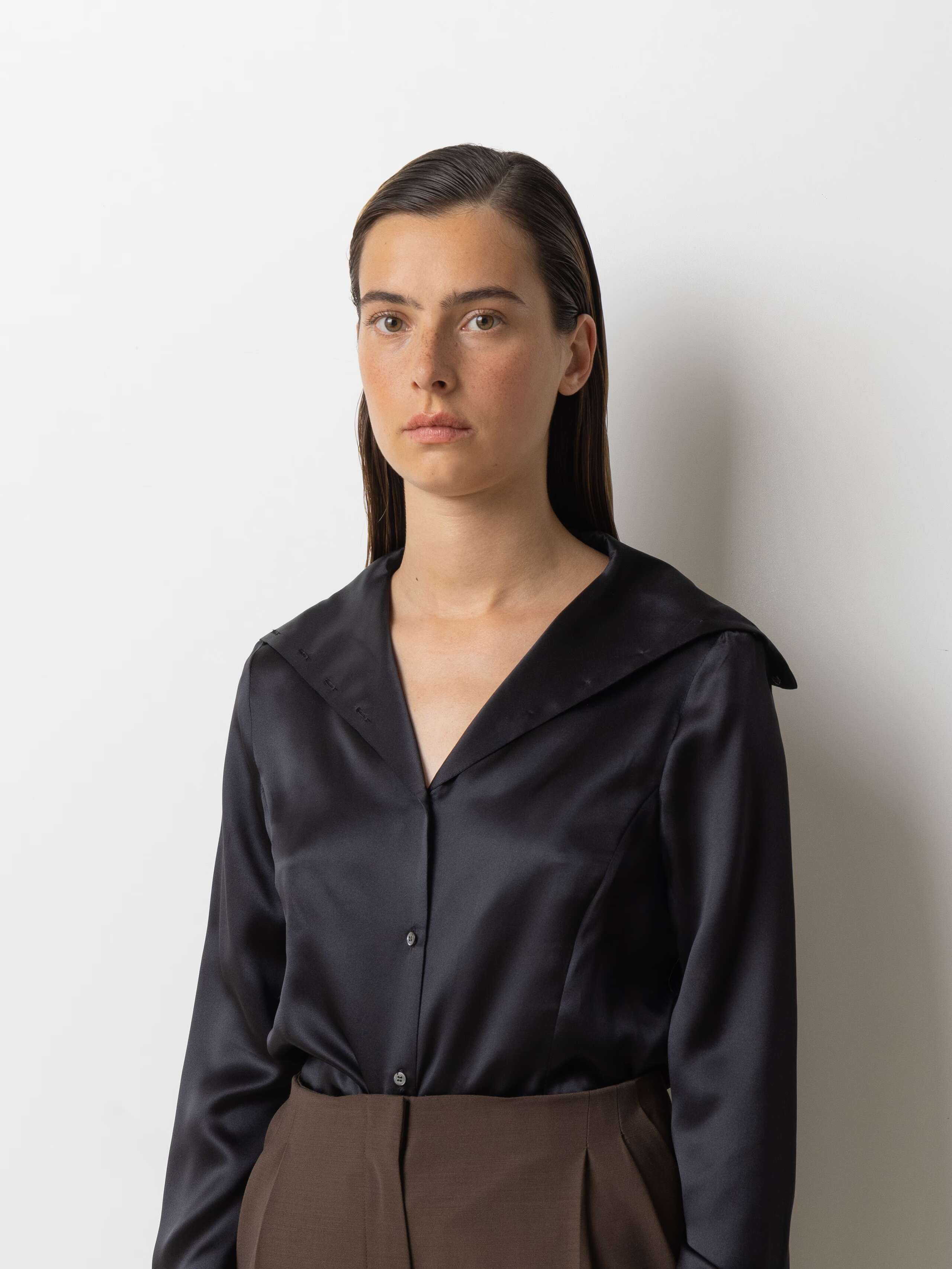 Picture of a female model wearing a black silk blouse