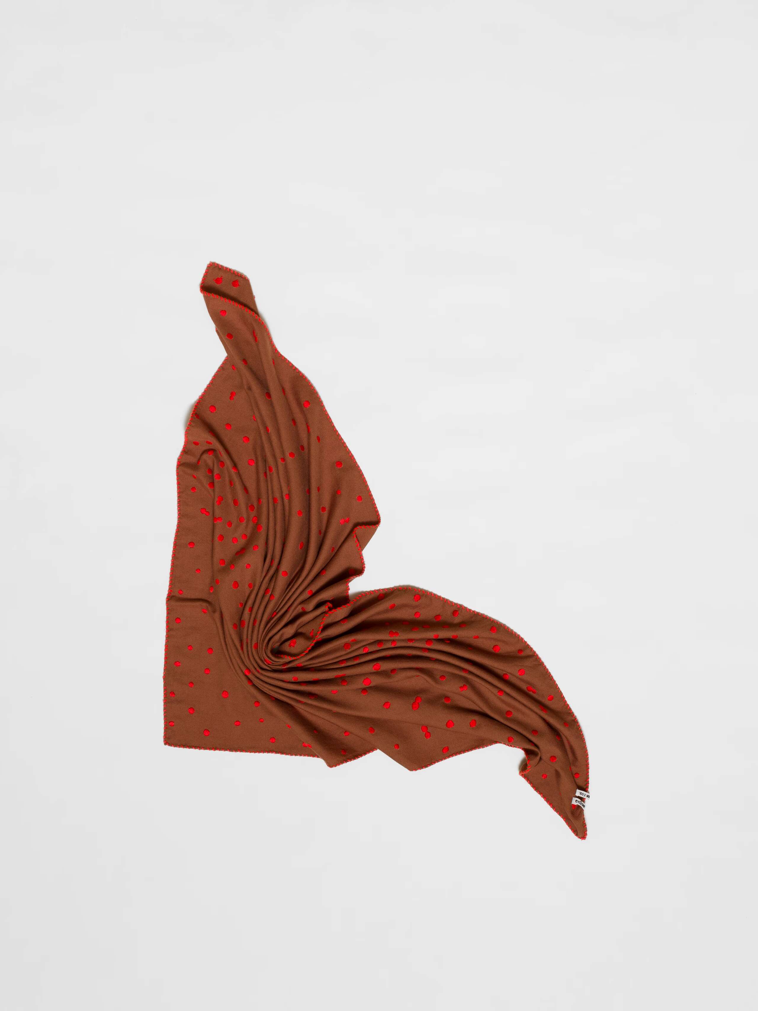 Picture of a wool foulard in brown featuring red hand embroidered dots