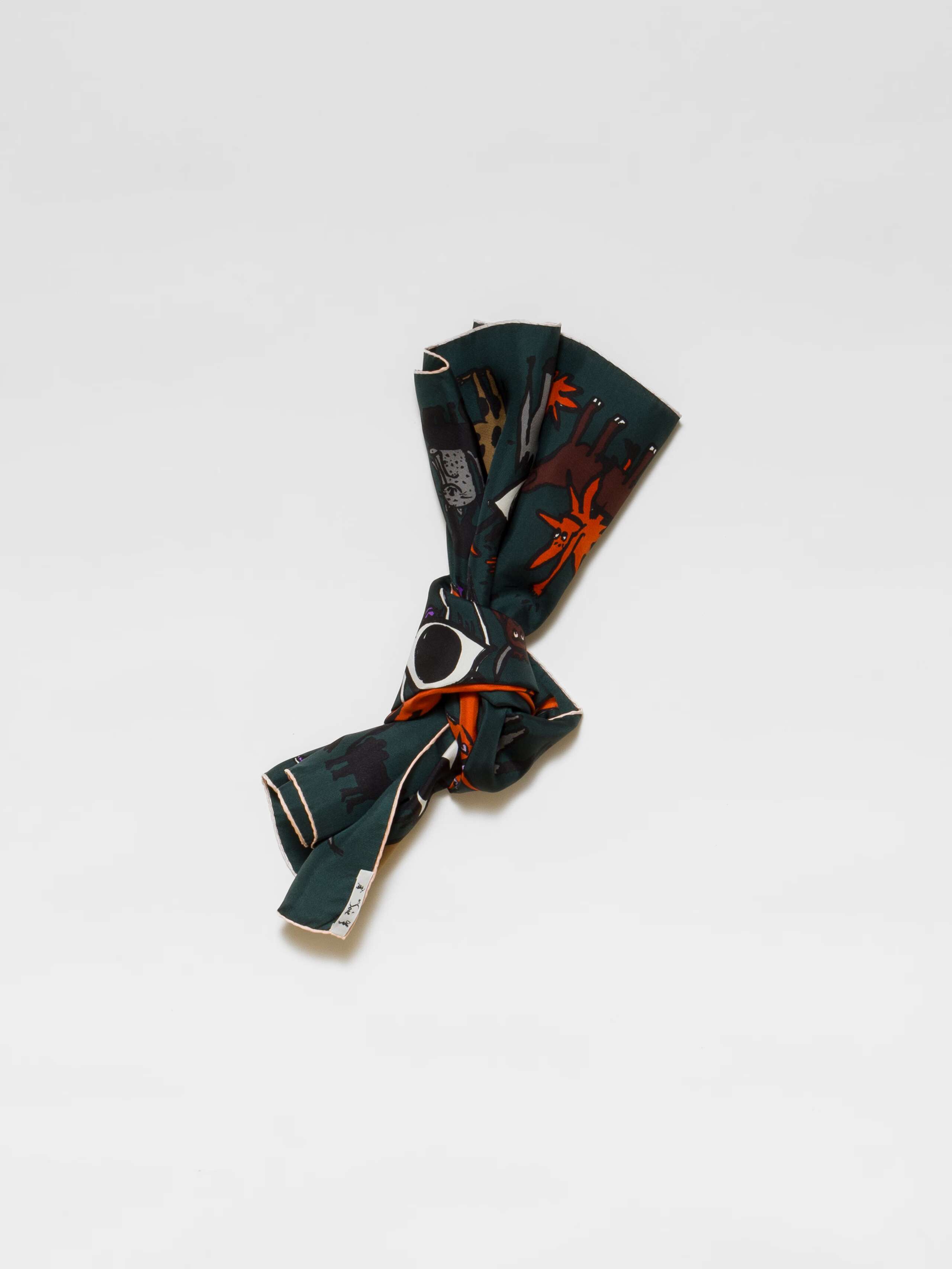 Picture of a dark green silk foulard featuring a red sun surrounded by lots of funny, colourful creatures 