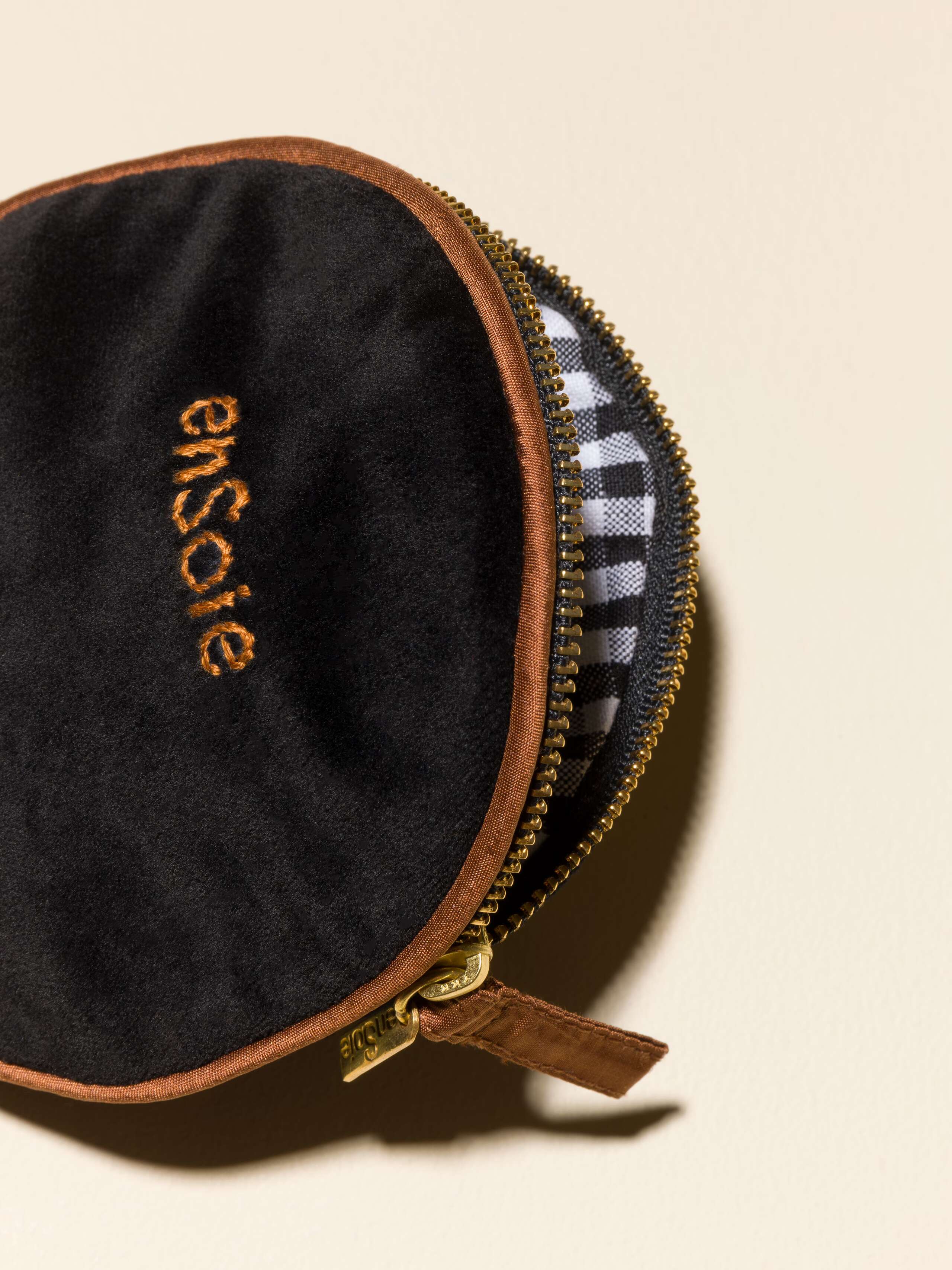 Picture of a detail of a black velvet bag featuring brown silk borders and a beautiful striped inlay