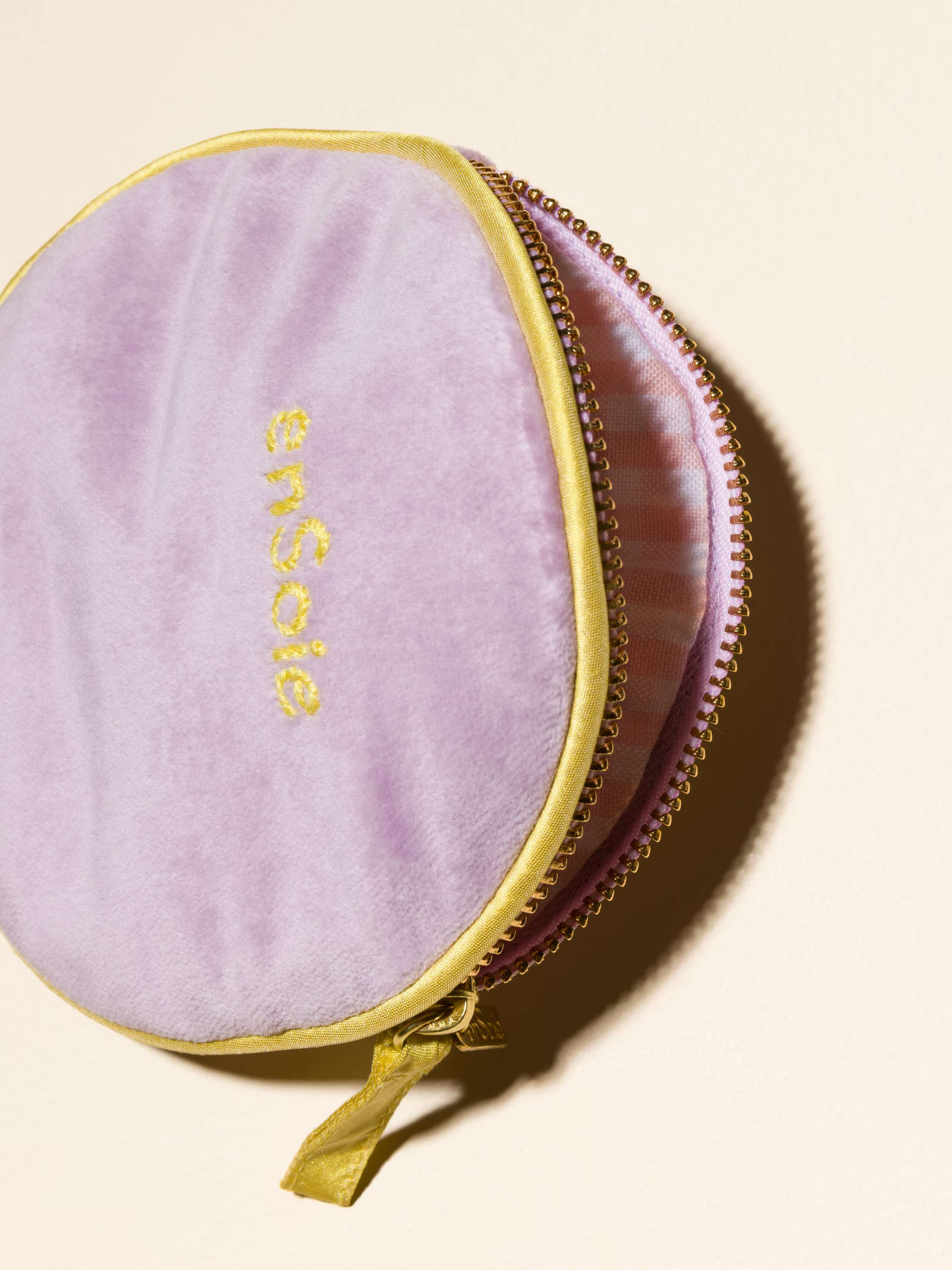 Picture of a detail of a velvet bag in a beautiful lavender shade featuring yellow silk borders and a beautiful striped inlay
