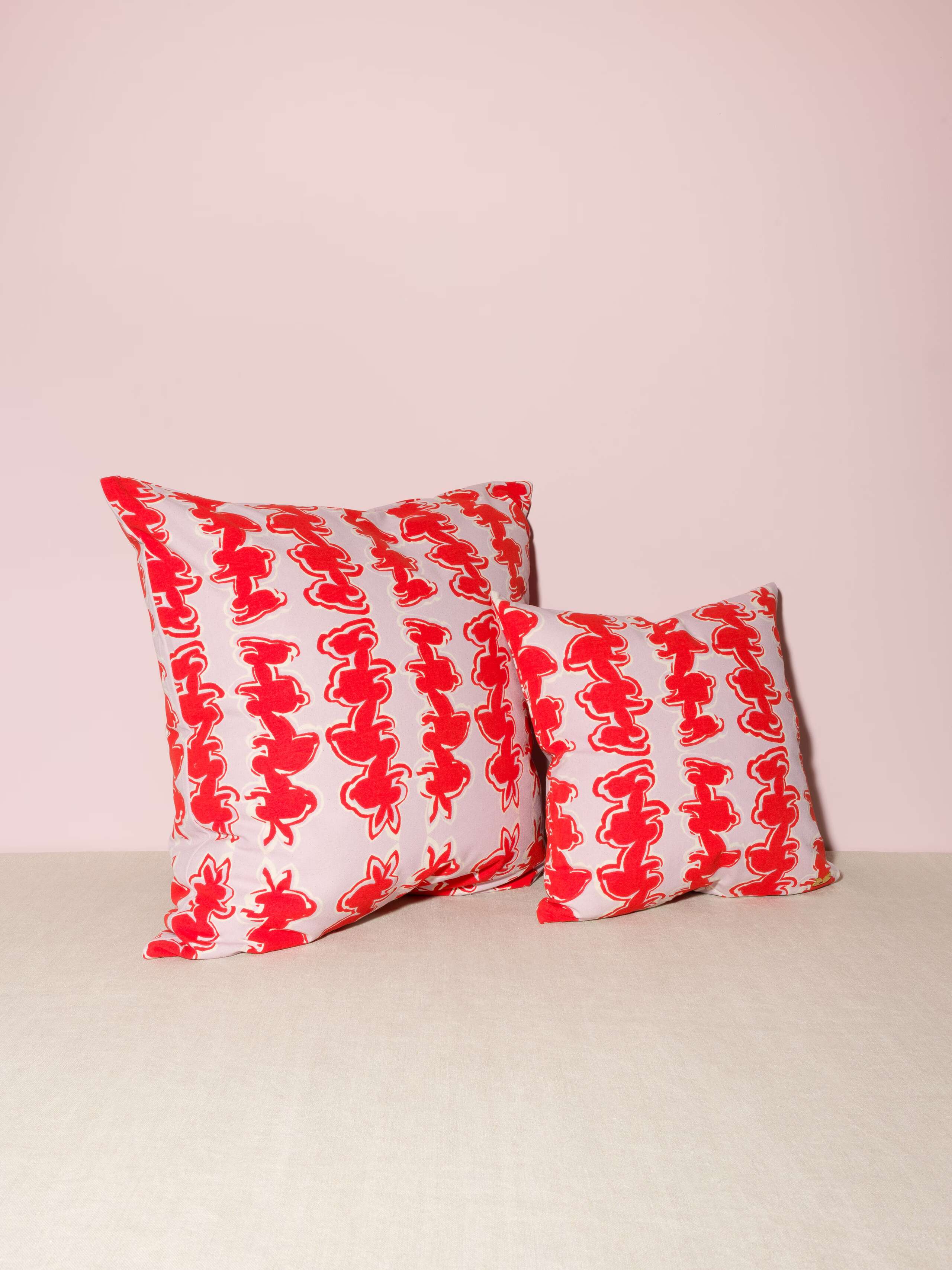 Picture of two pillows in two sizes featuring a beautiful rabbit print in red on a lavender ground