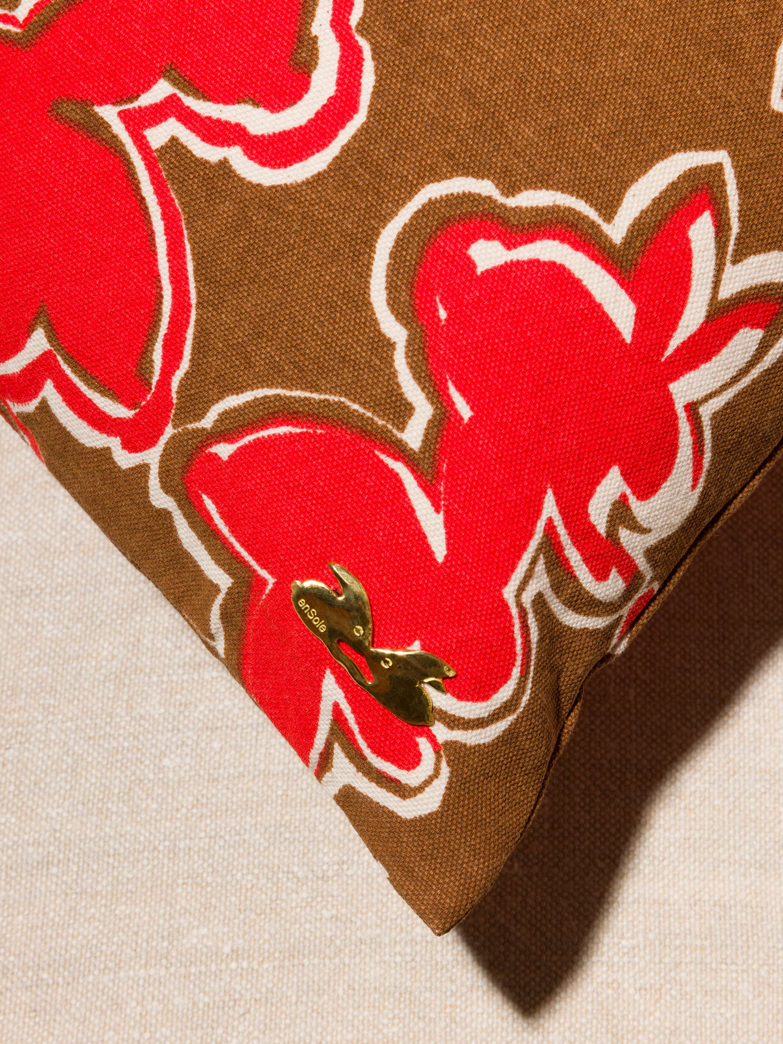 Picture of a brass detail of a cotton canvas pillow cover in a beautiful warm brown 
