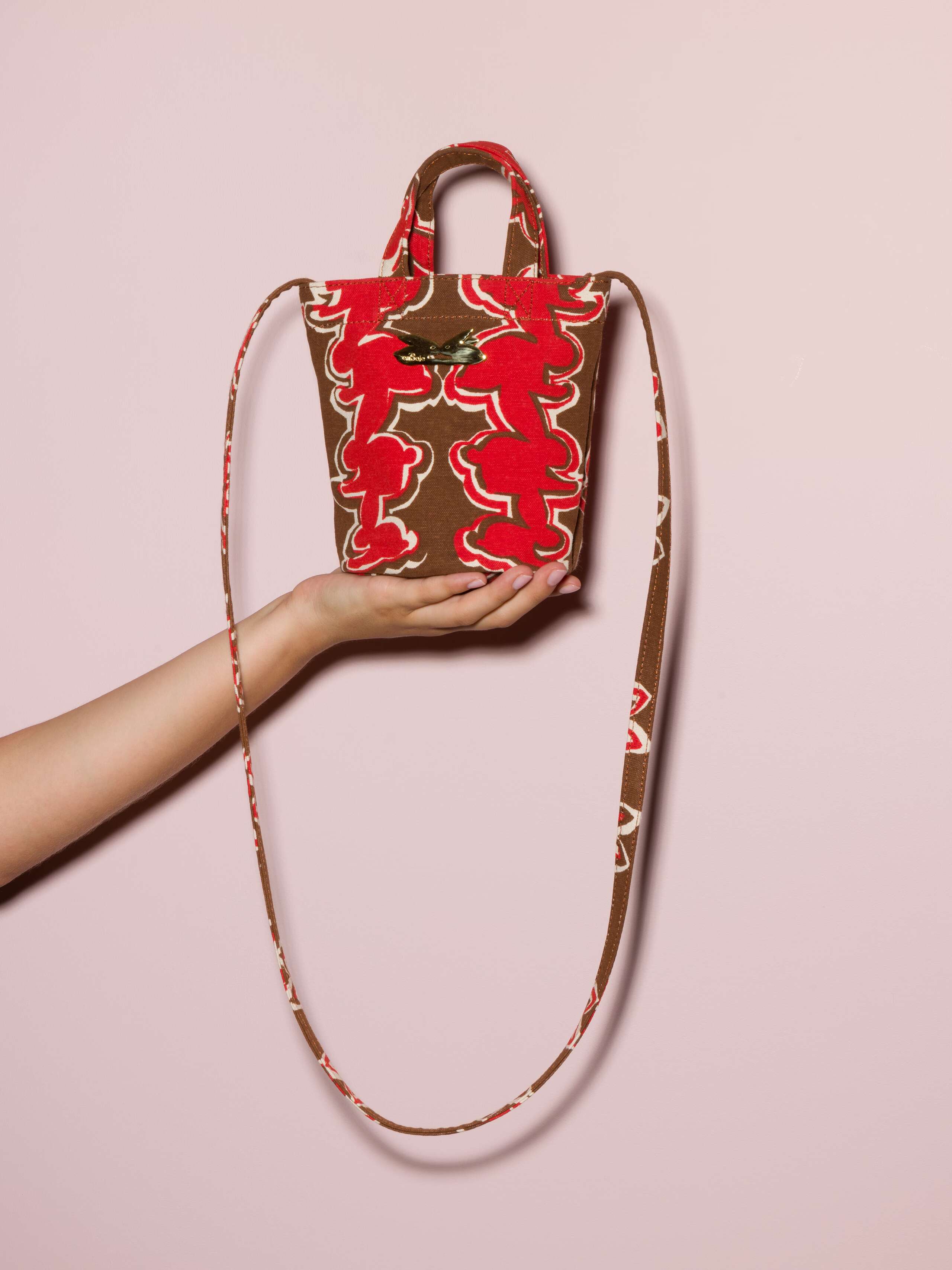 Picture of a small cotton canvas bag featuring a red rabbit print on a brown ground