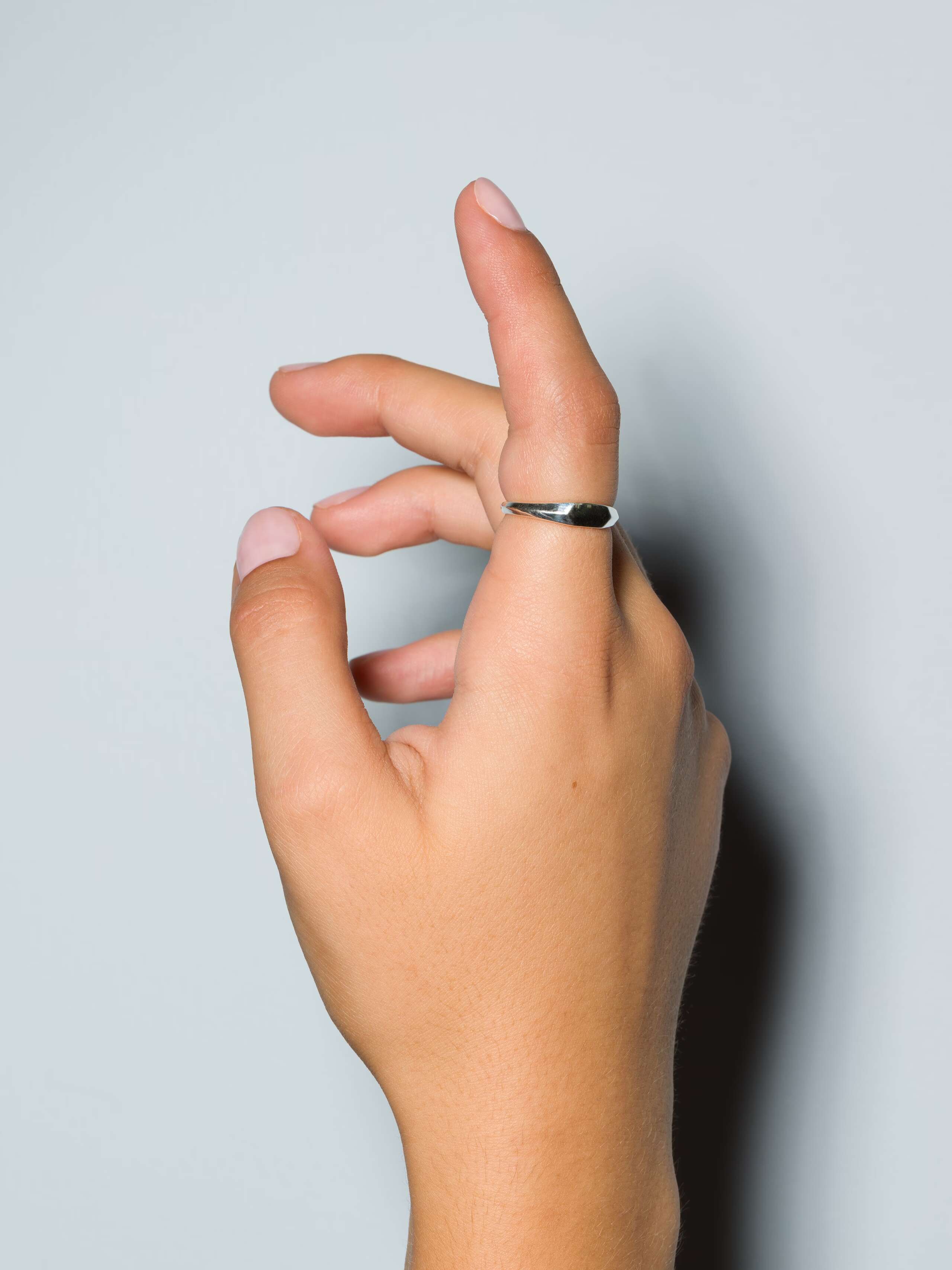 Small sterling silver signet ring called Ida on a set of hands