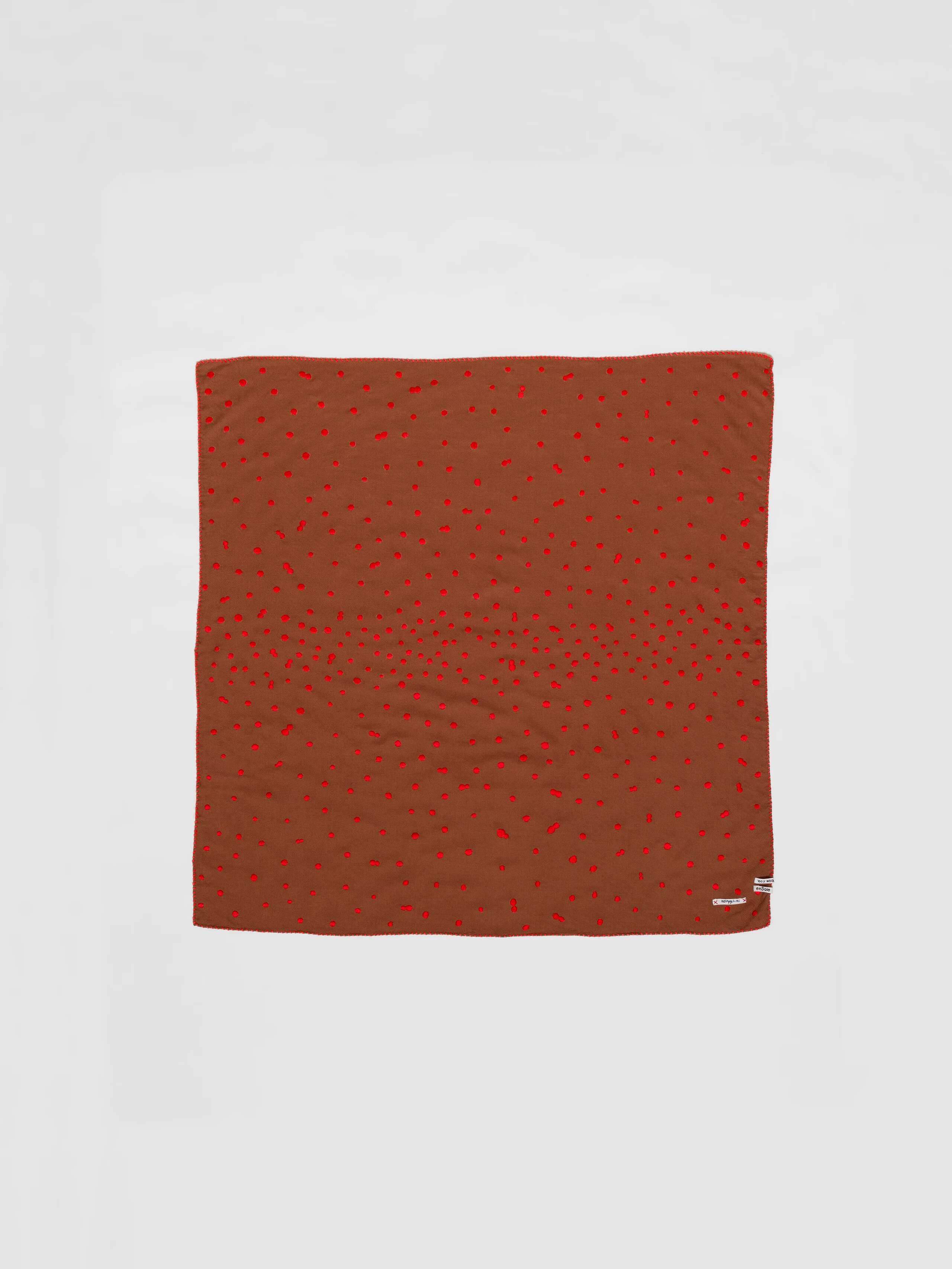 Picture of a wool foulard in brown featuring red hand embroidered dots