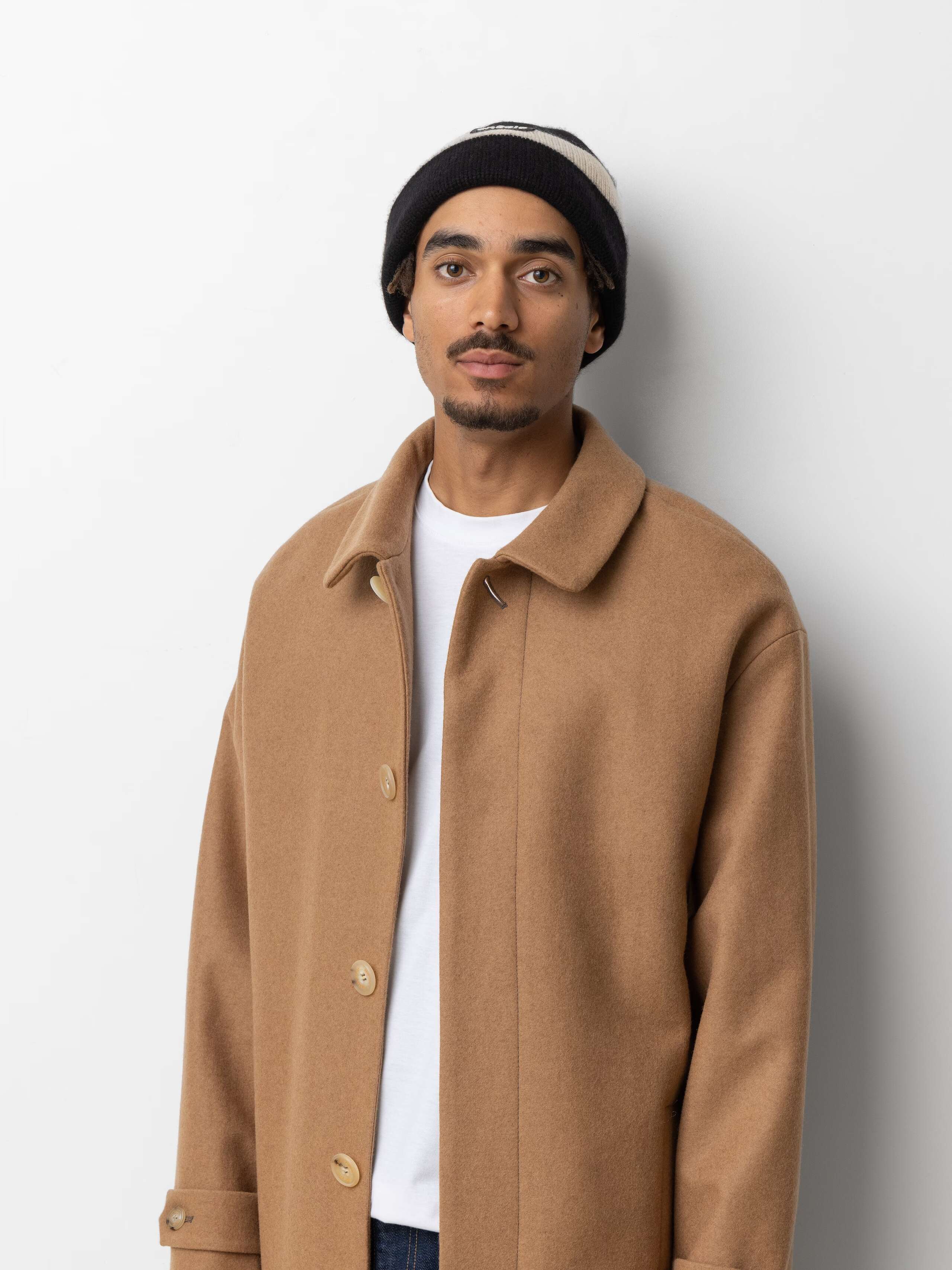 Picture of a male model wearing a black and white striped cashmere beanie