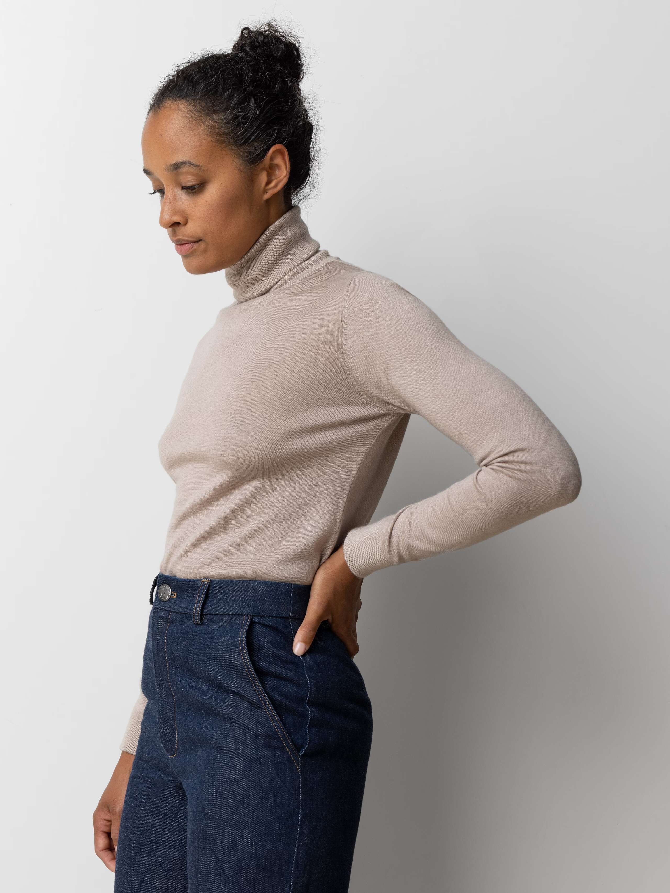 Picture of a female model wearing a beige cashmere turtleneck