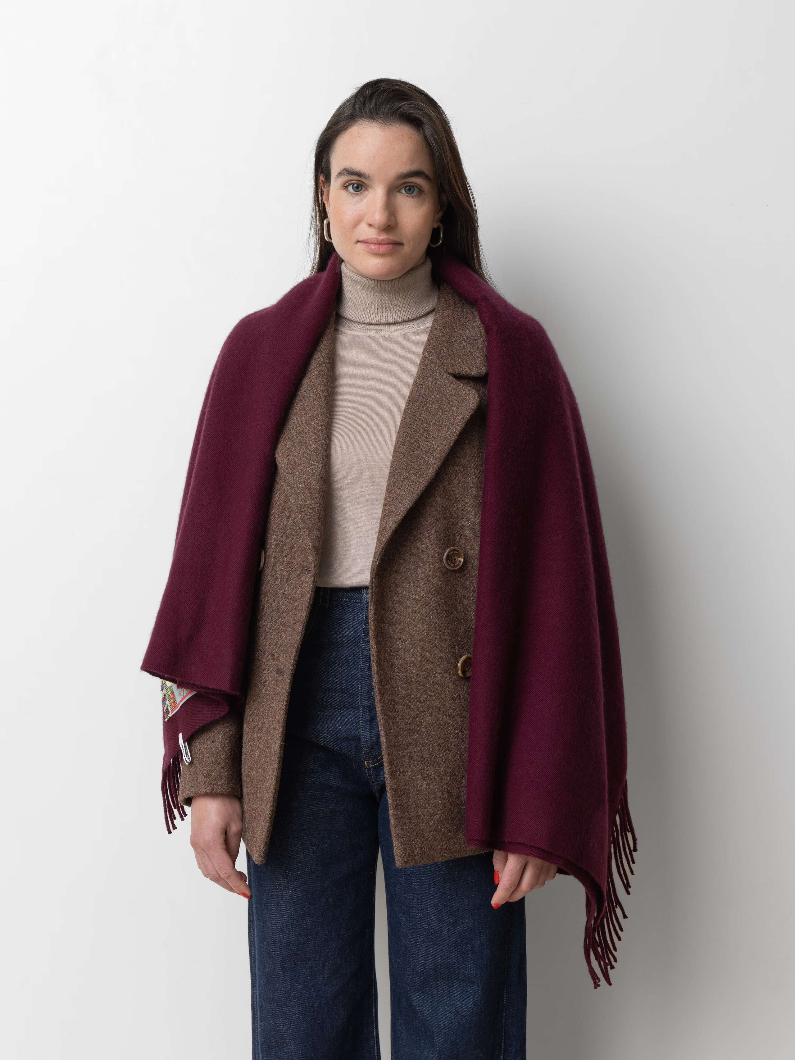Picture of a female model wearing a jeans in combination with a beige cashmere turtleneck and a burgundy cashmere stole 