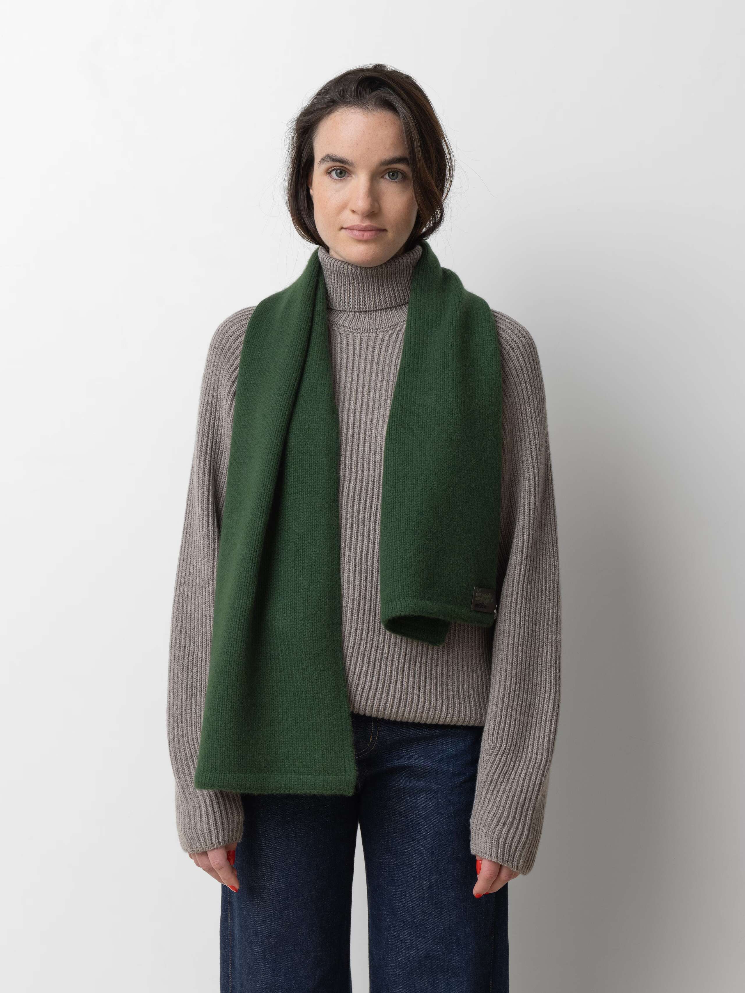 Picture of a female model wearing a green cashmere scarf